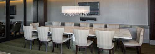 AMLI Design District resident conference room with long table and 12 chairs with modern white light fixture hanging above