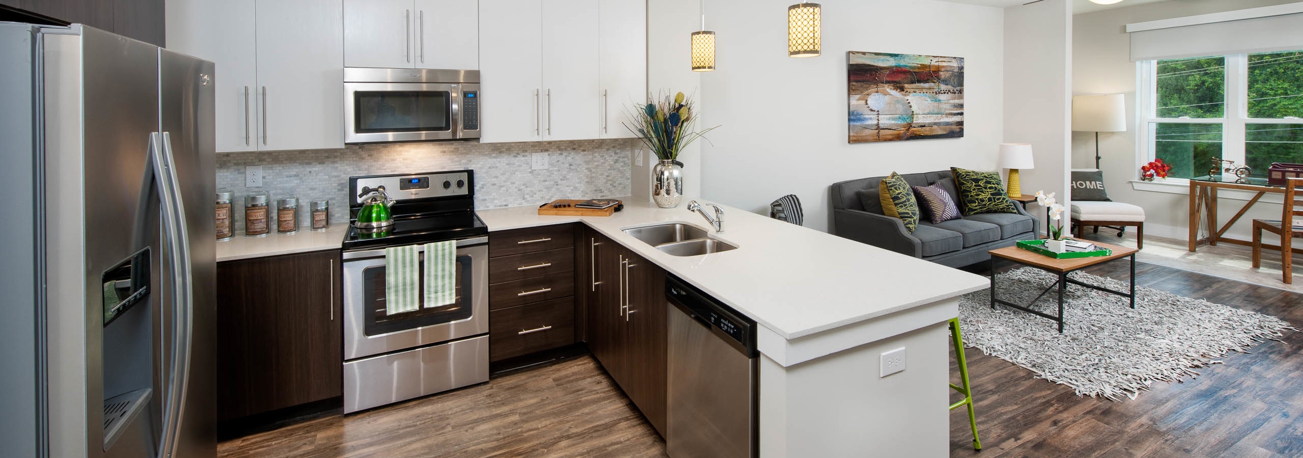 AMLI Piedmont Heights kitchen with stainless steel appliances and both white and dark wood cabinets with light hardwood