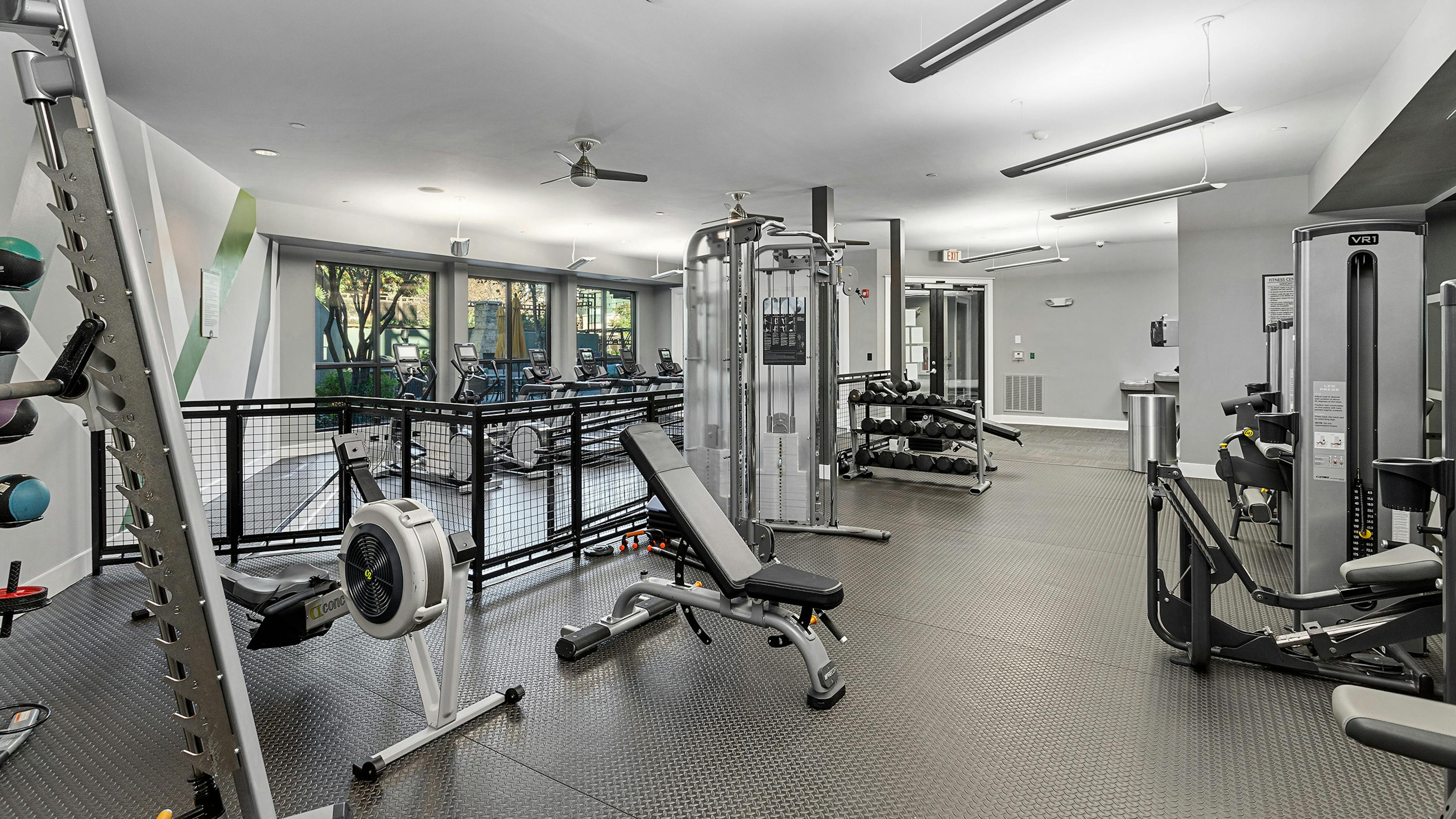 Interior view of the fitness center at AMLI Parkside apartments with weight machines that overlook the treadmills