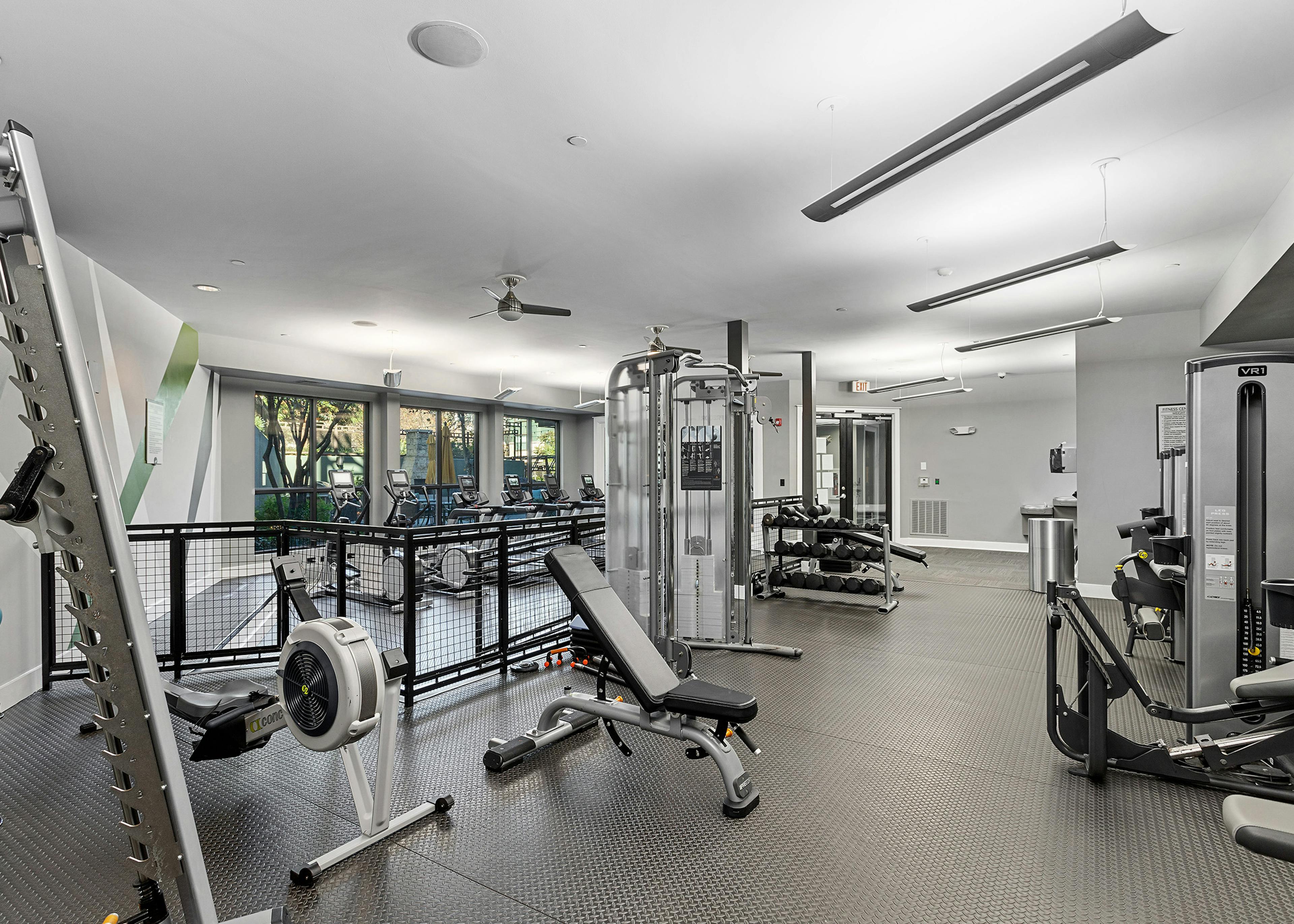 Interior view of the fitness center at AMLI Parkside apartments with weight machines that overlook the treadmills