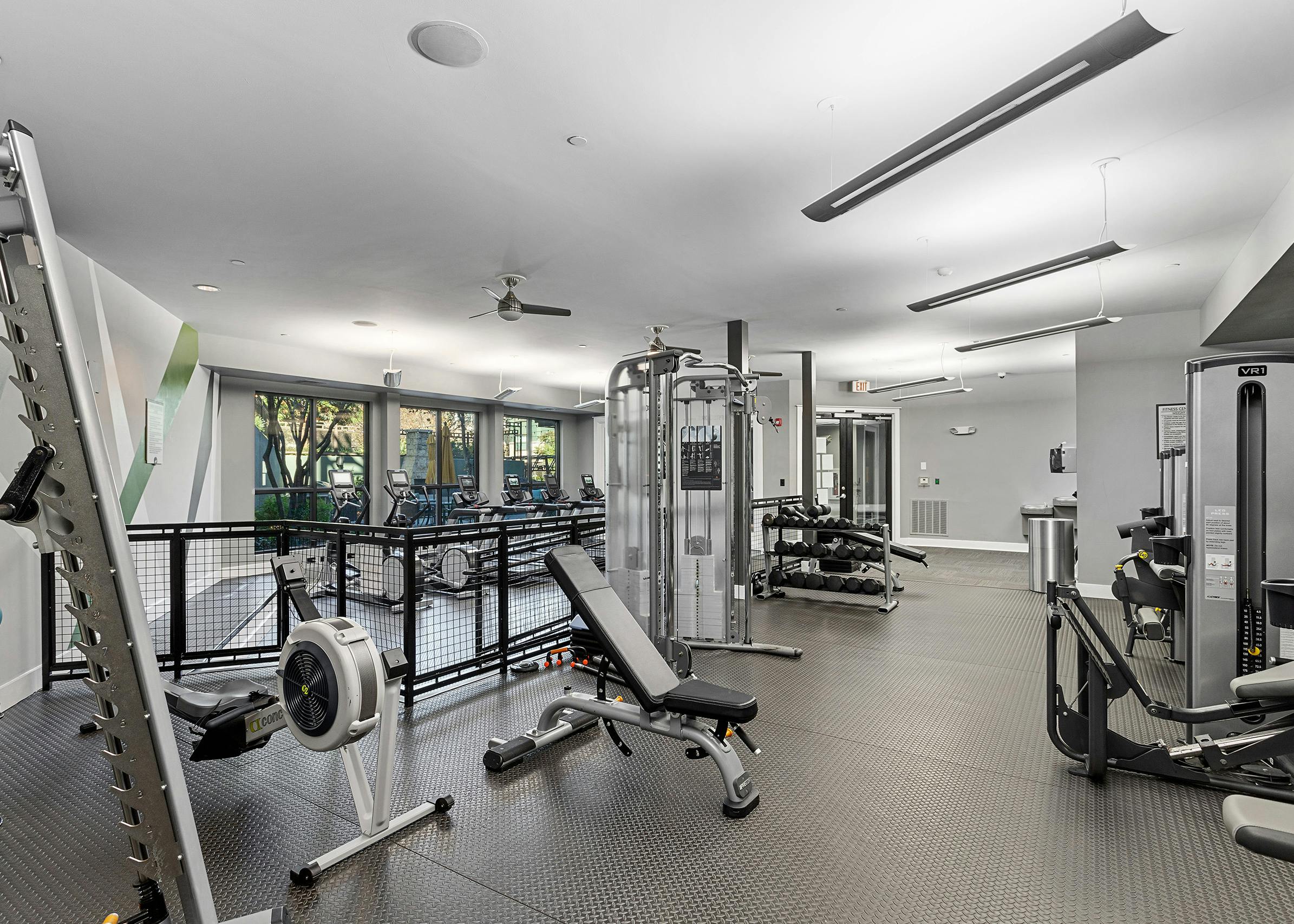 Interior view of the fitness center at AMLI Parkside apartments with weight machines that overlook the treadmills