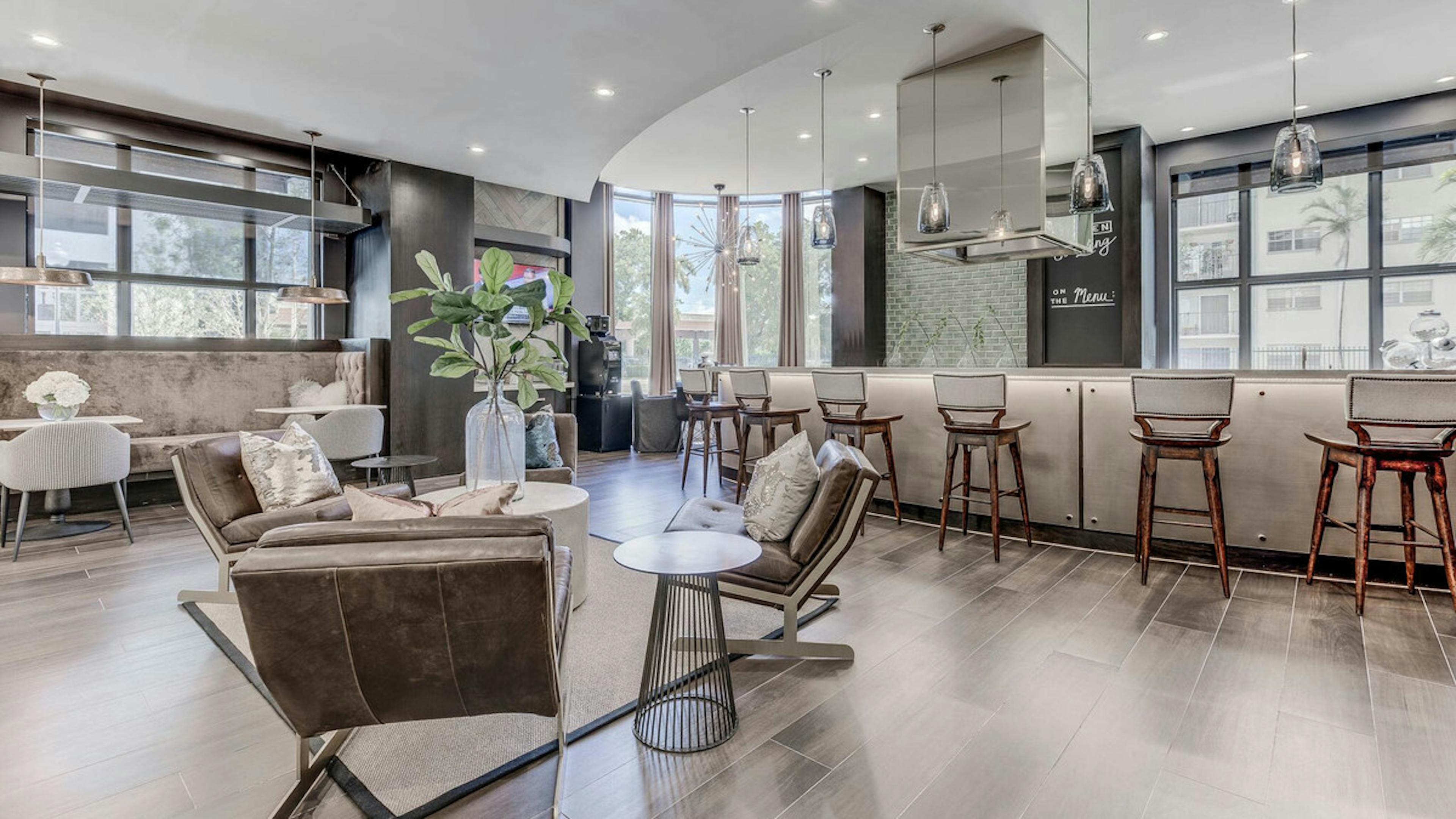 Interior view of the resident lounge at AMLI Joya apartments with modern décor, seating area and large island with stools 