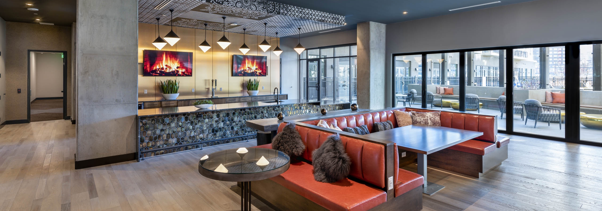 Interior view of resident lounge at AMLI Art District with a large marble bar area with cold brew coffee taps and televisions