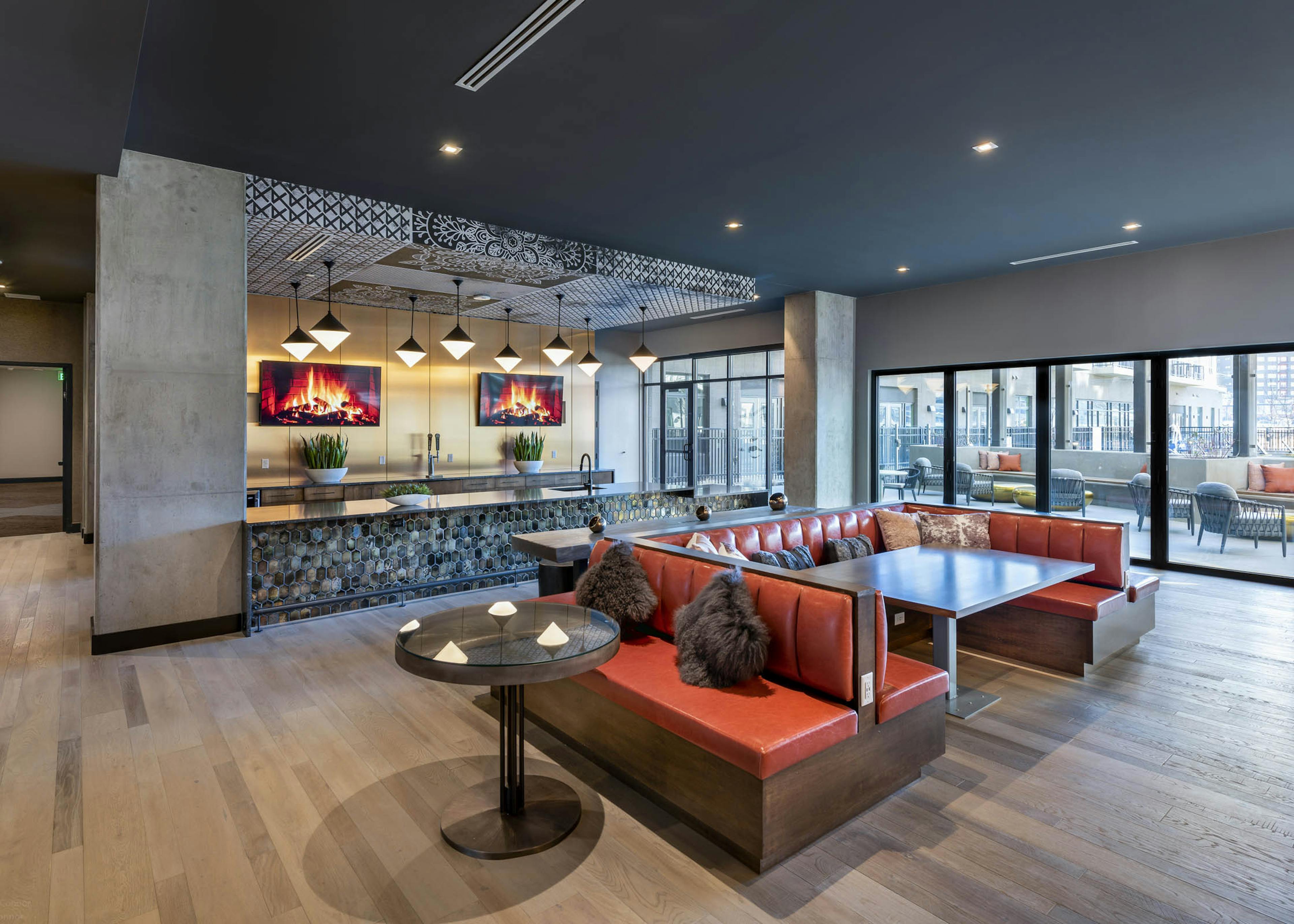 Interior view of resident lounge at AMLI Art District with a large marble bar area with cold brew coffee taps and televisions