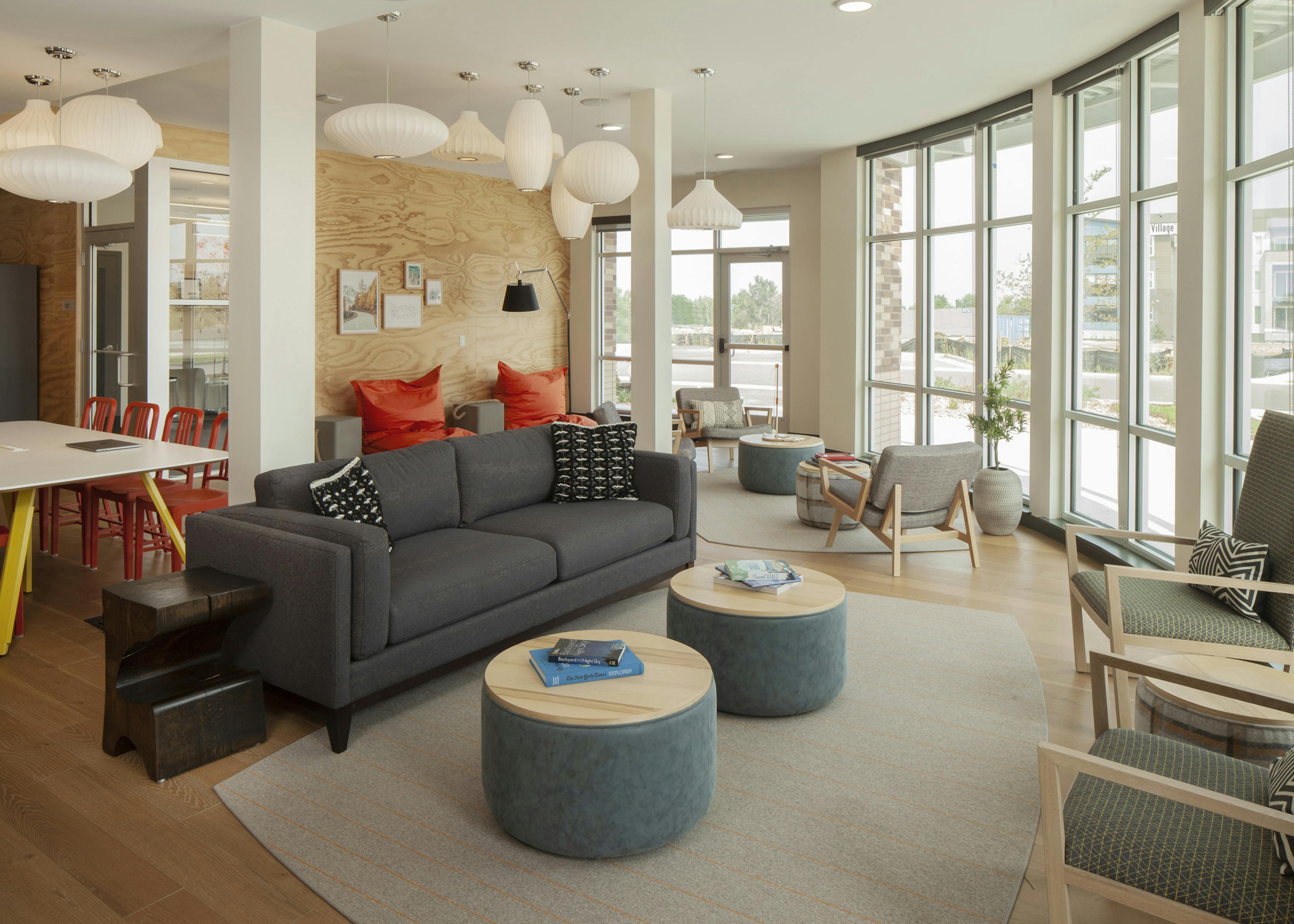 Interior view of AMLI Littleton Village cyber café with floor to ceiling windows and hardwood floors and several seating areas 