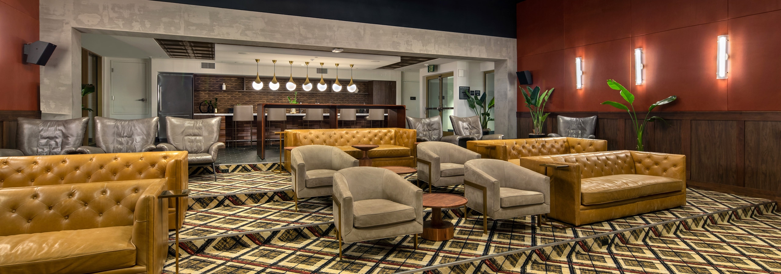 Interior of theatre room with ample lounge seating under a lit and decorative ceiling with chandeliers at AMLI Old Pasadena