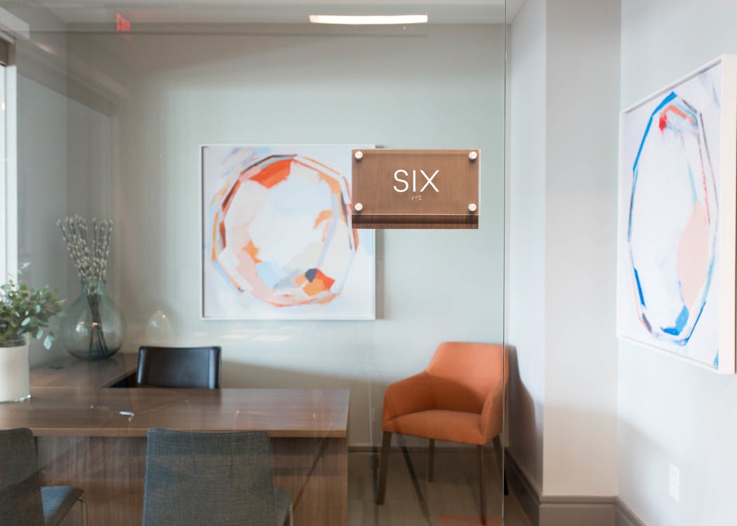 AMLI 3464 private office with a wood desk and an orange office chair in the corner matching a large hanging wall art piece