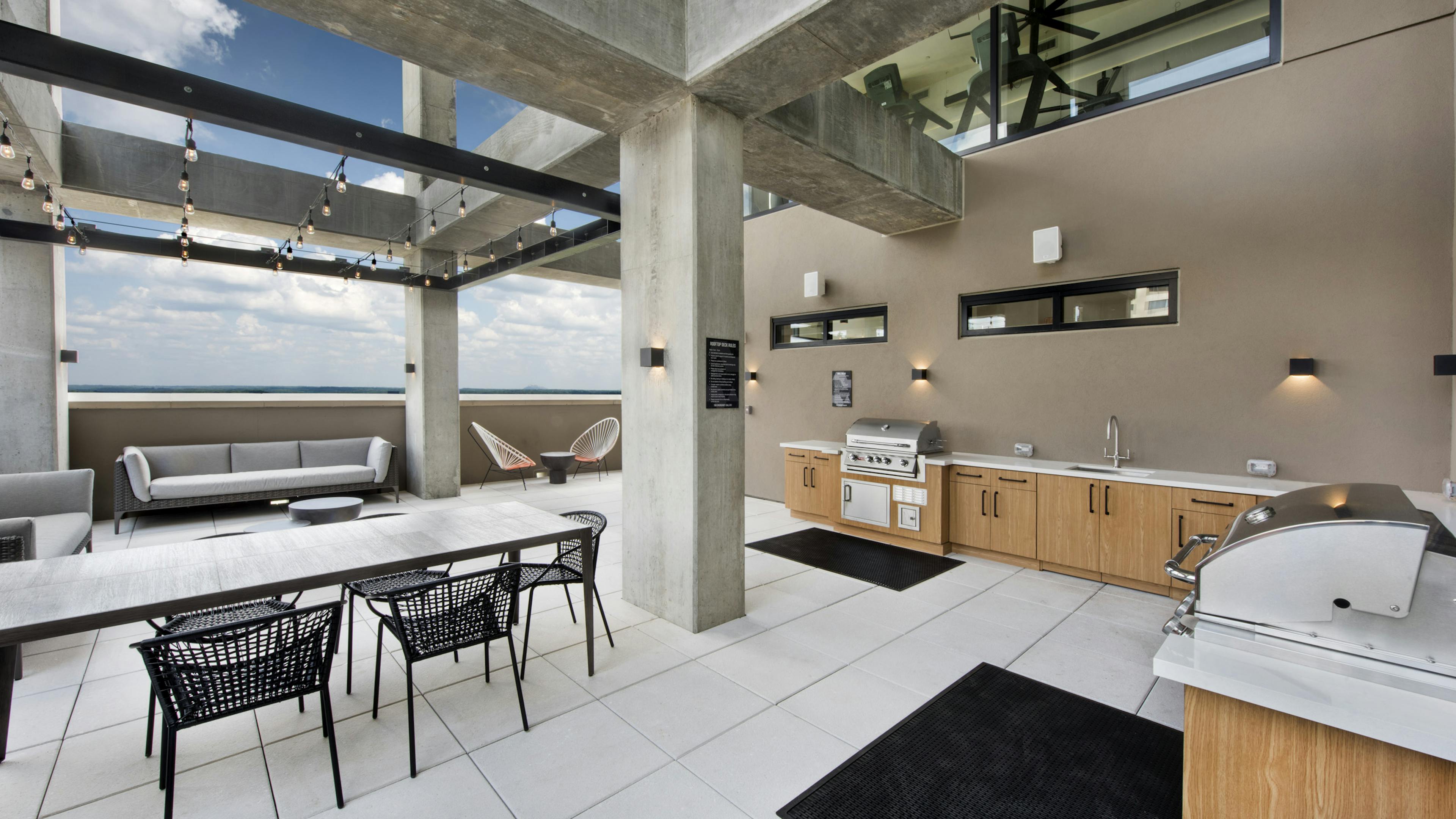 Outside view of AMLI Lenox rooftop with two grills and sink and lots of storage space with multiple seating areas