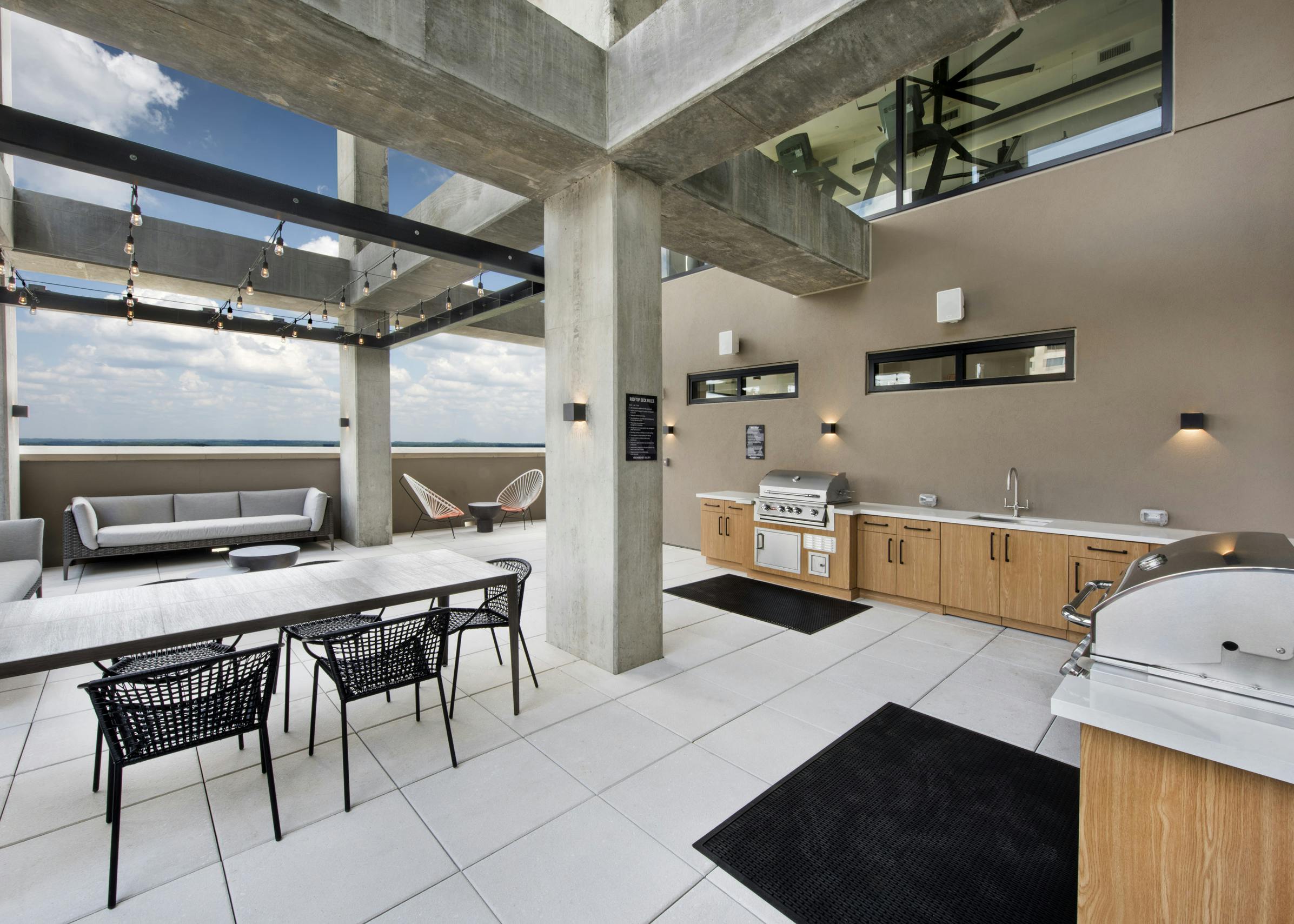 Outside view of AMLI Lenox rooftop with two grills and sink and lots of storage space with multiple seating areas