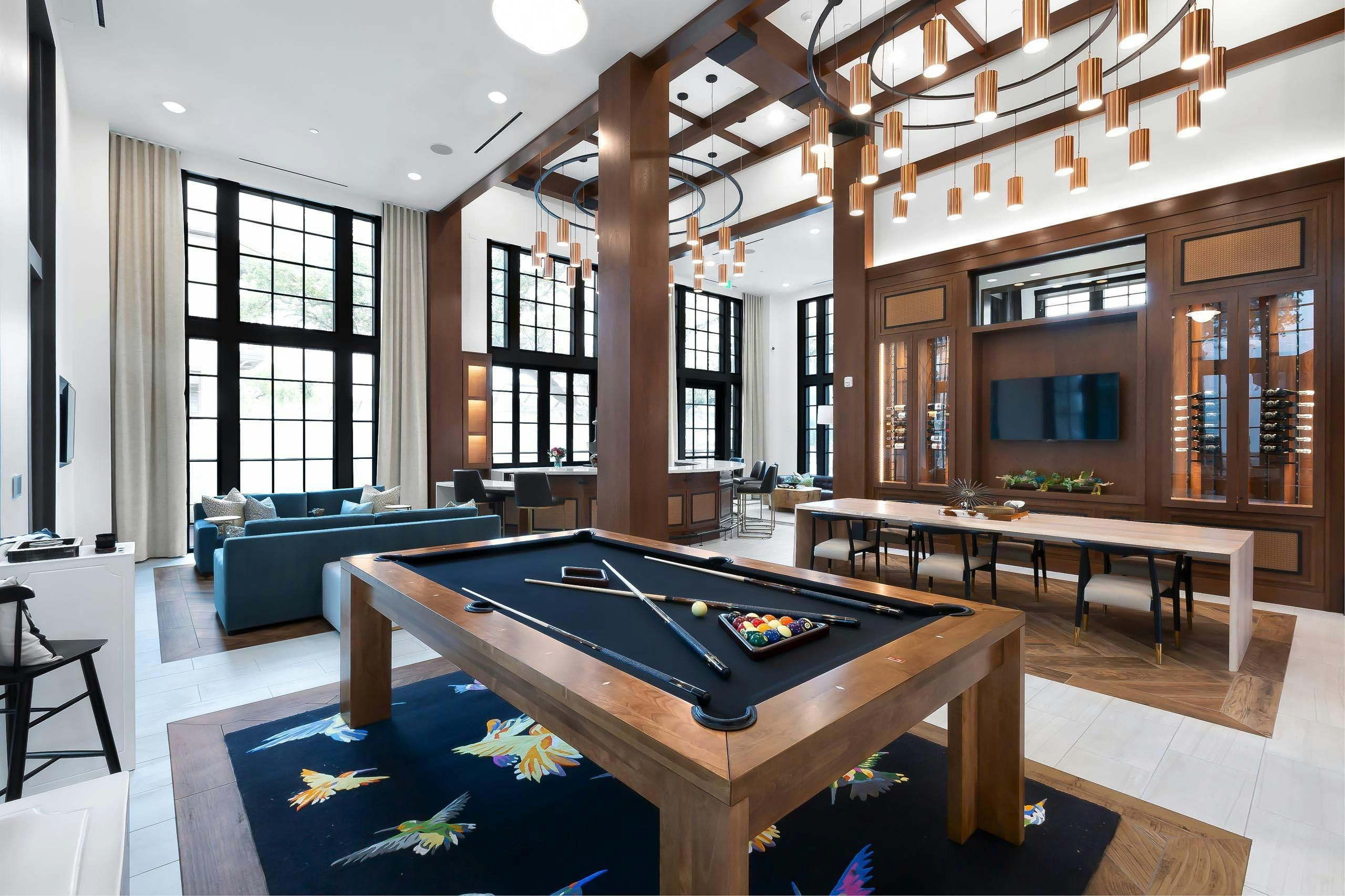 Resident lounge at AMLI Lakeline apartments with a wooden billiards table and a TV flanked by two wine storage cabinets