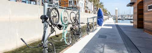 Daytime view of the marina walkway by the boat house, paddleboard rack and bicycle rack at AMLI Marina Del Rey apartments