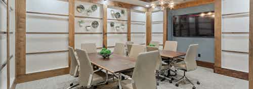 AMLI Old 4th Ward newly renovated conference room with two large wooden tables and six beige leather rolling chairs at each