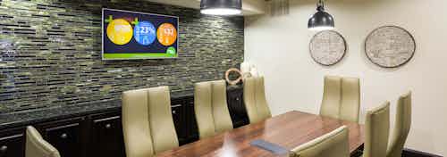 Interior of conference room at AMLI Campion Trail apartment building with wood table and eight chairs and big screen TV
