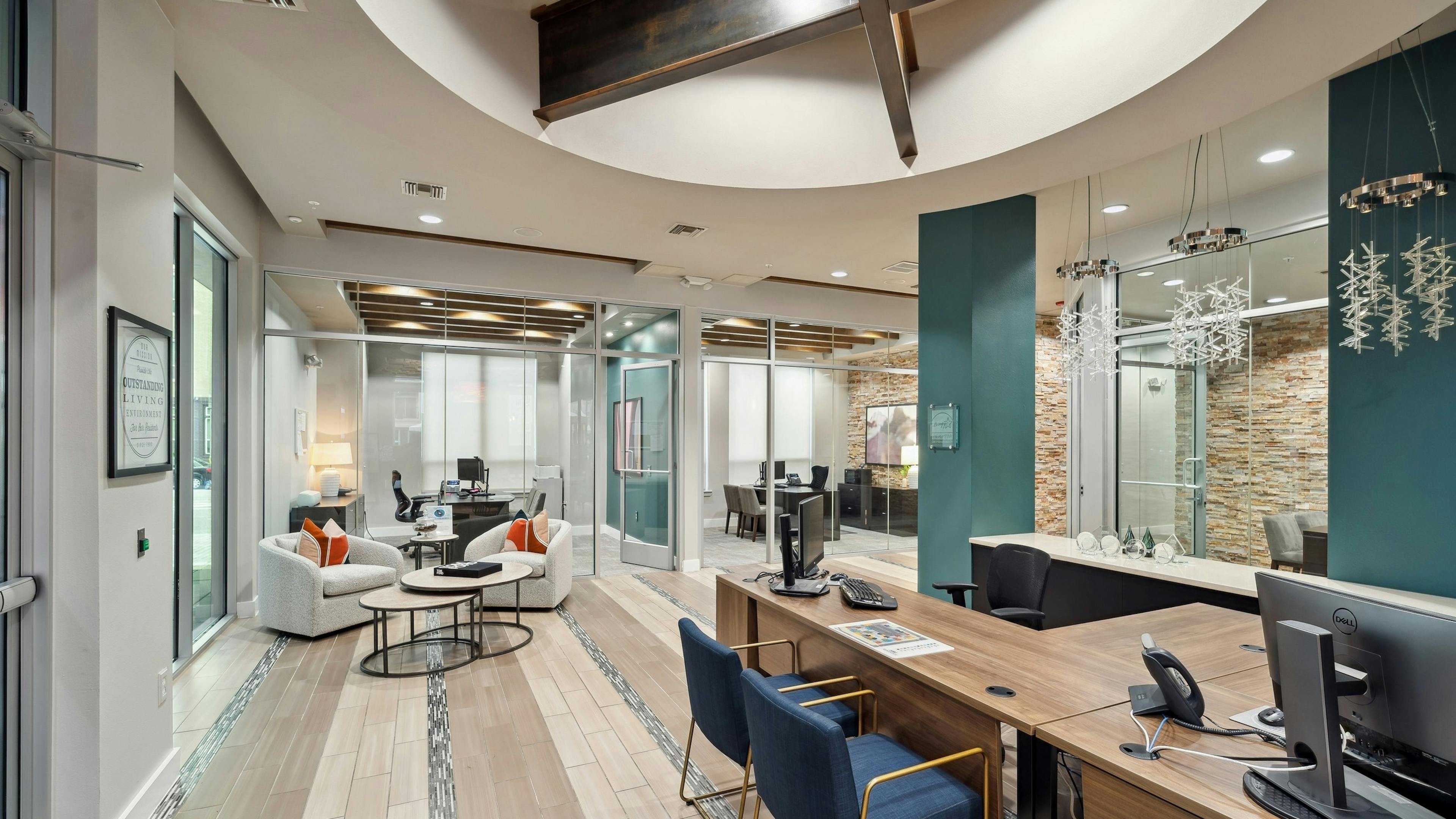 Interior view of a leasing office at AMLI RidgeGate with tile flooring and desks with computers and offices with glass walls