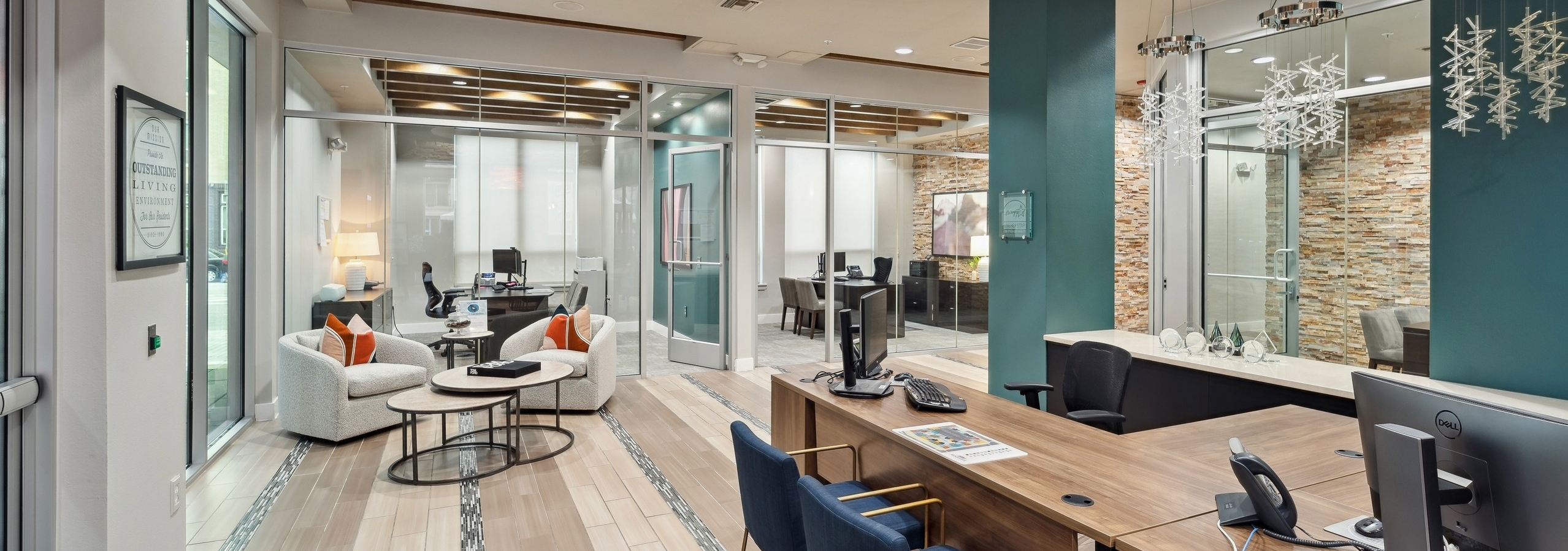 Interior view of a leasing office at AMLI RidgeGate with tile flooring and desks with computers and offices with glass walls
