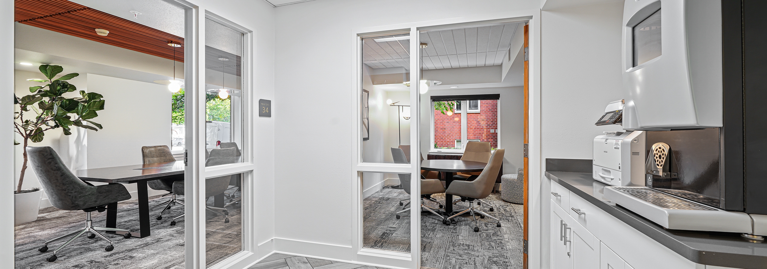 View into two private conference rooms at AMLI Bellevue Park  apartments with Starbucks coffee machine on countertop