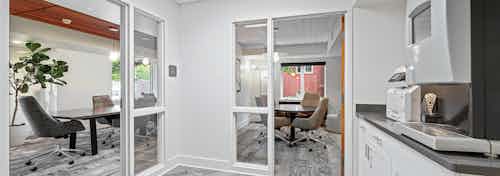 View into two private conference rooms at AMLI Bellevue Park apartments with Starbucks coffee machine on countertop