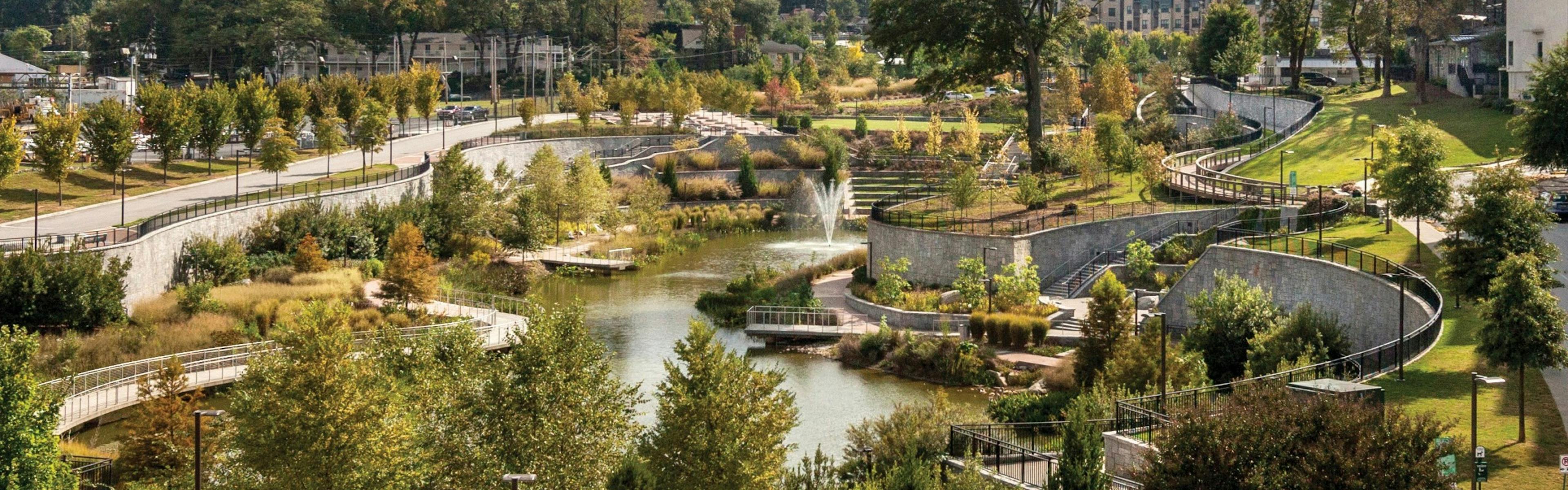 Exterior view of Historic Old 4th Ward Park with luscious landscaping surrounding a beautiful pond with walking trails