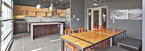 AMLI South Lake Union rooftop indoor club room with large wood community table full kitchen and Starbucks coffee machine