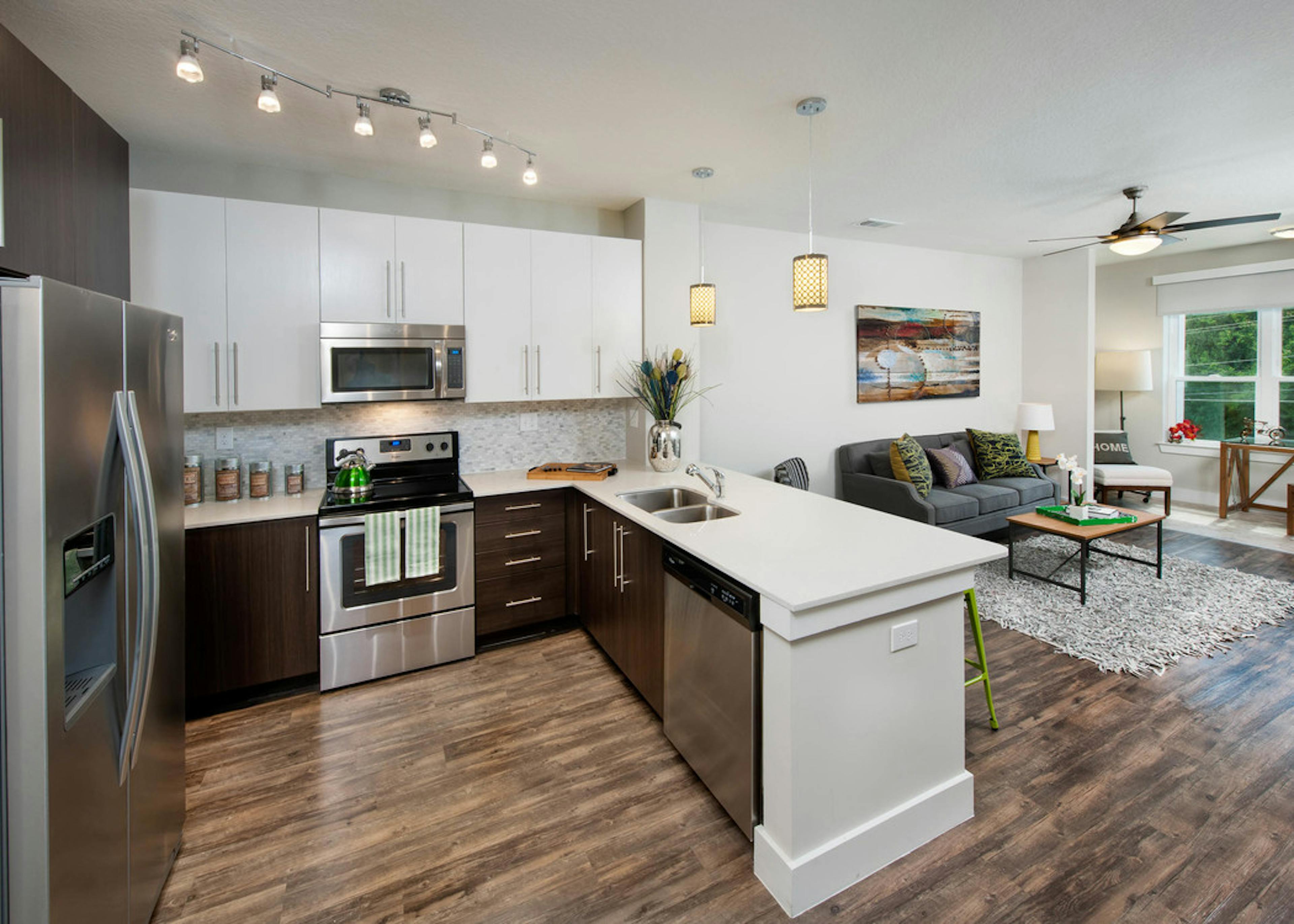 AMLI Piedmont Heights kitchen with stainless steel appliances and both white and dark wood cabinets with light hardwood