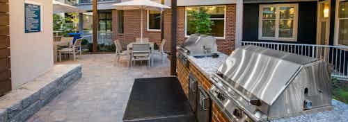 AMLI Buckhead barbecue area with grills and outdoor counter space and stone flooring leading to area with tables and chairs