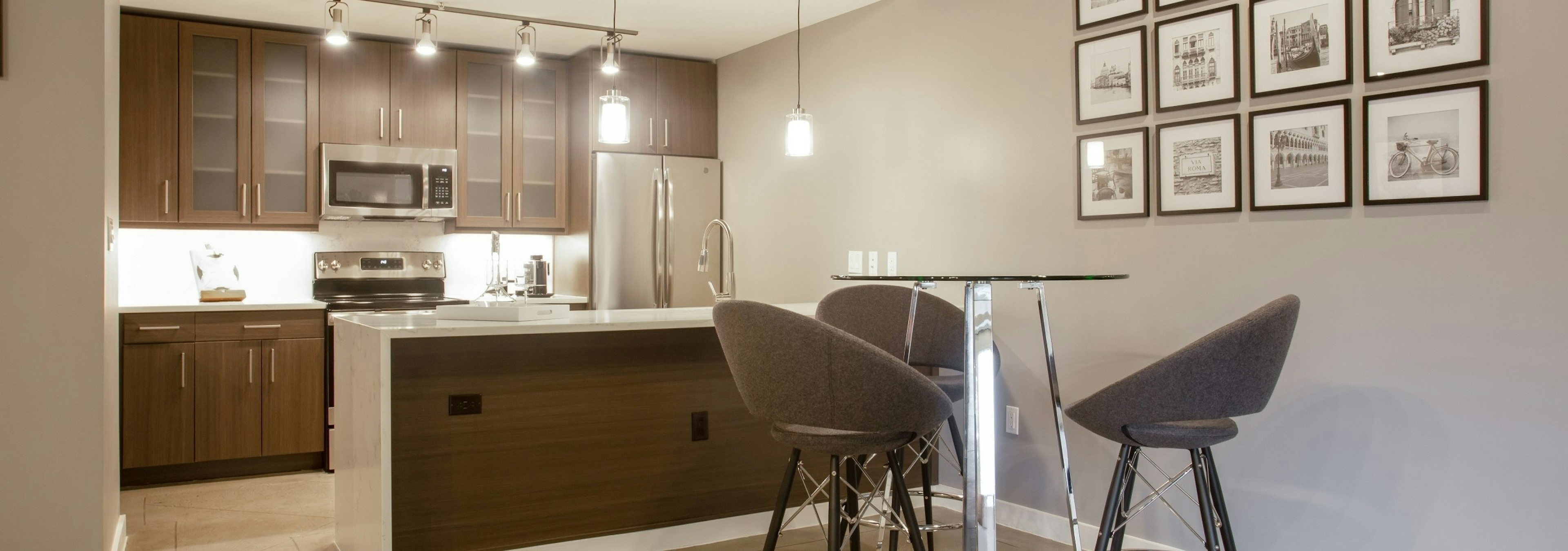 Kitchen at AMLI Downtown with a photo frame collage on the wall with dark cabinets and light countertops