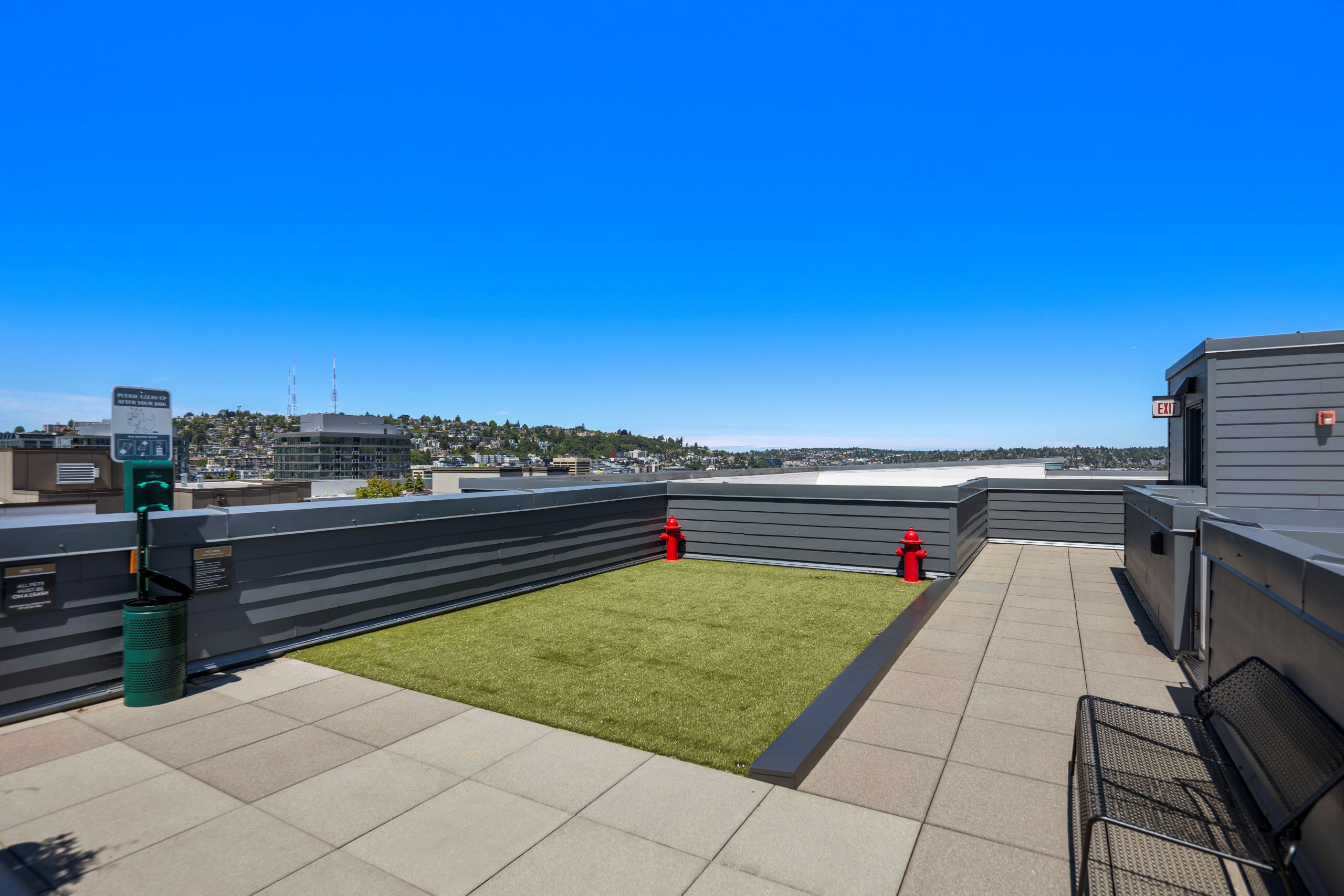 AMLI 535 rooftop pet relief area with artificial turf, pet waste station, and panoramic city views.
