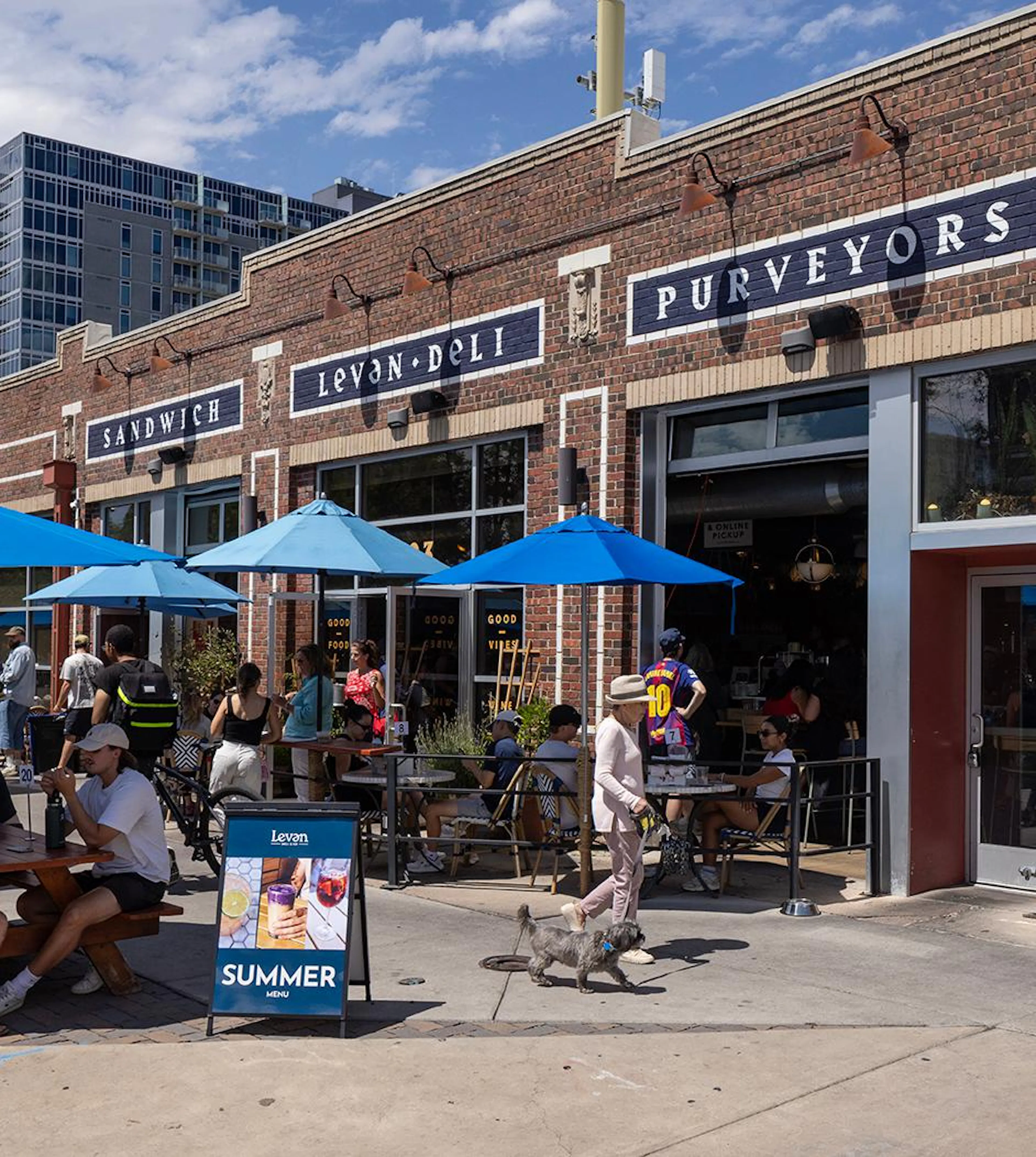 The exterior of Levan Deli near AMLI Golden Triangle with people seated at the outdoor tables on a sunny day