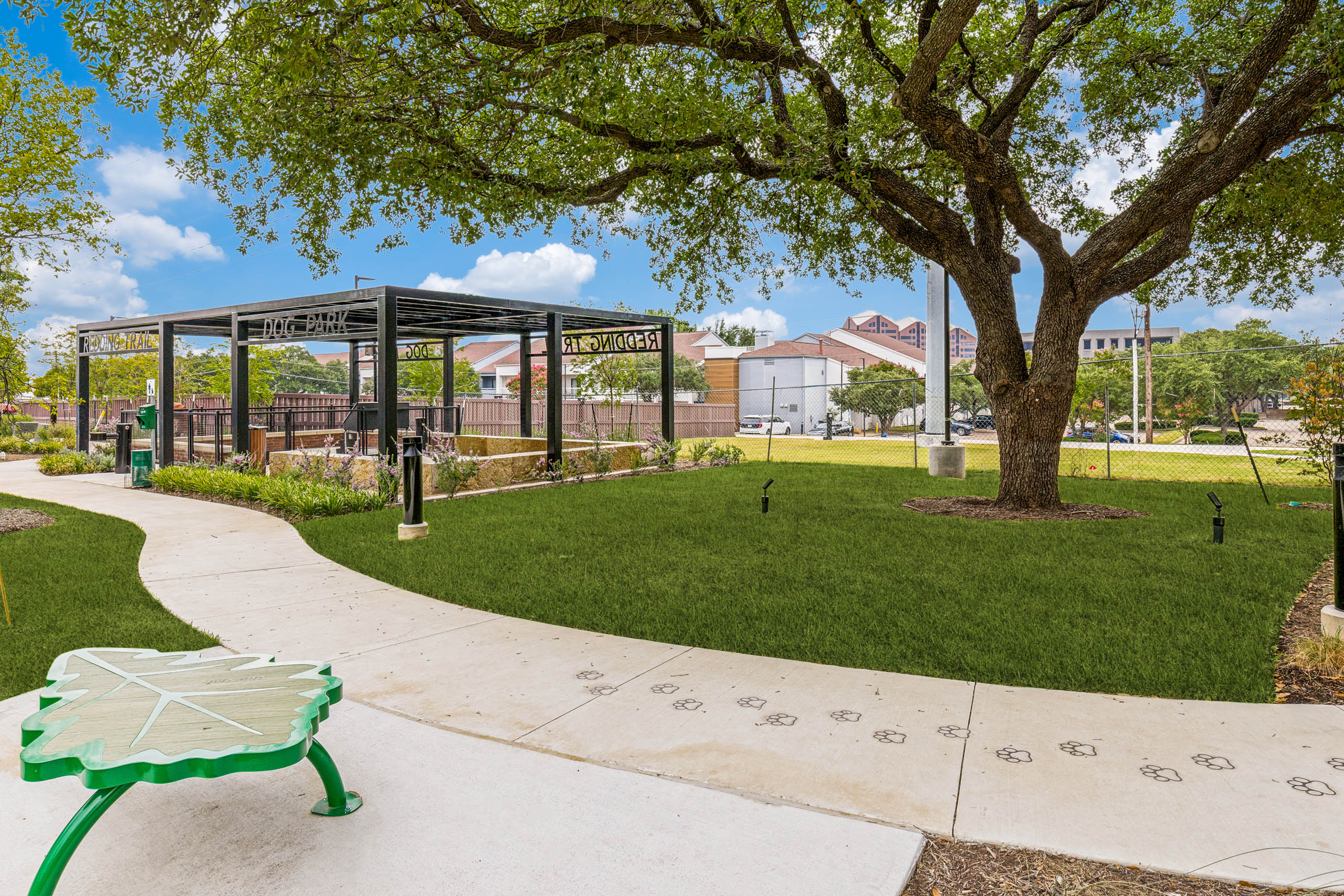 Open green space, covered pavilion, walking trail, decorative bench, and landscaped grounds at AMLI Treehouse.