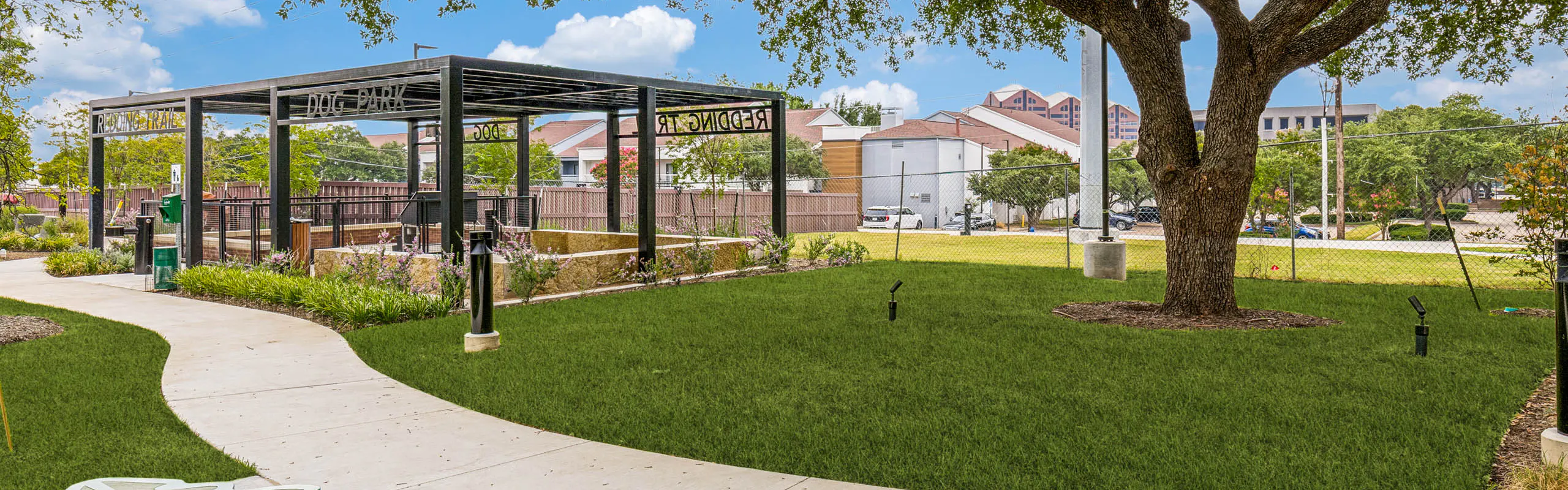 Open green space, covered pavilion, walking trail, decorative bench, and landscaped grounds at AMLI Treehouse.