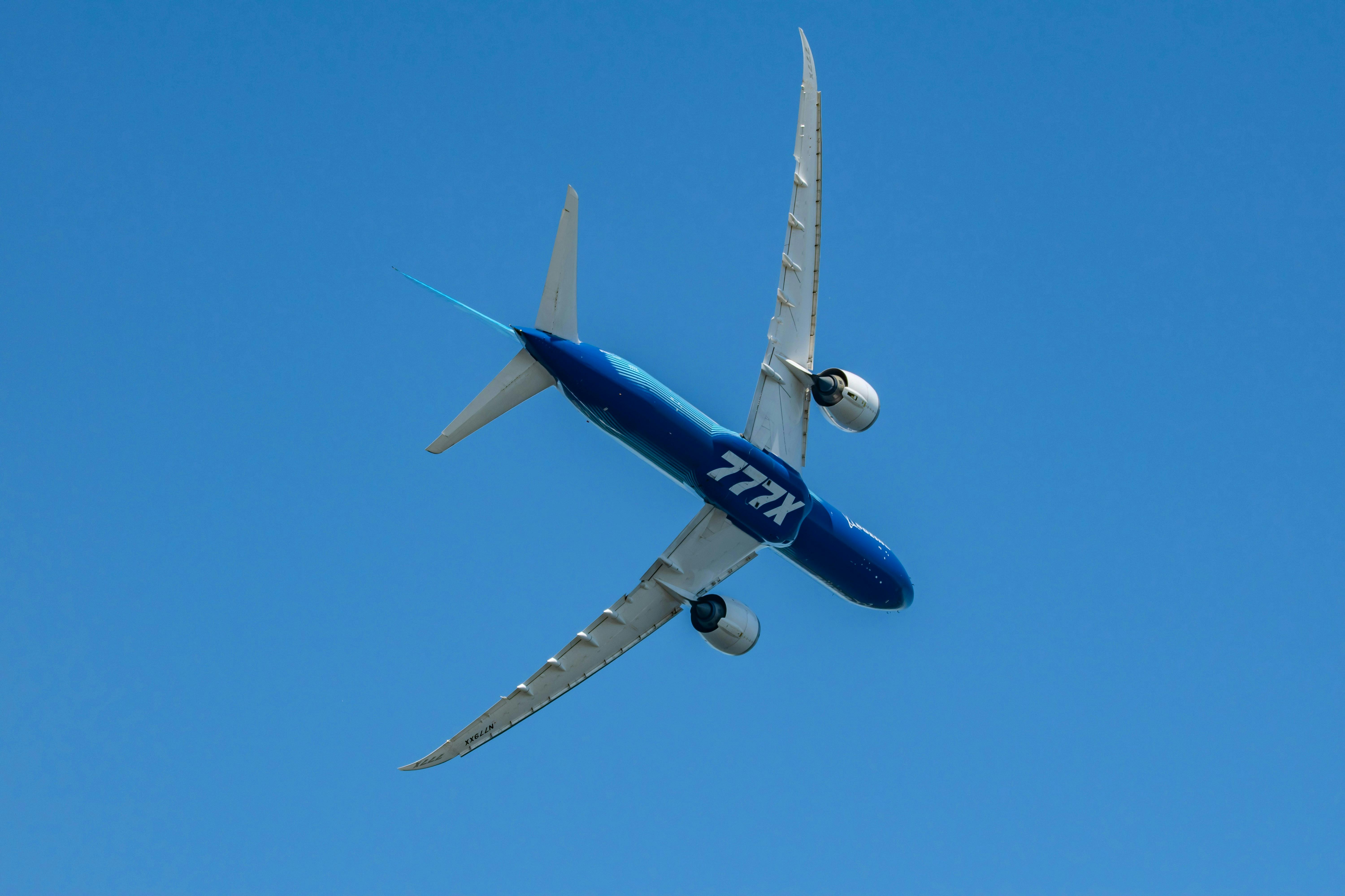 The underbelly of a Boeing 777x flying overhead