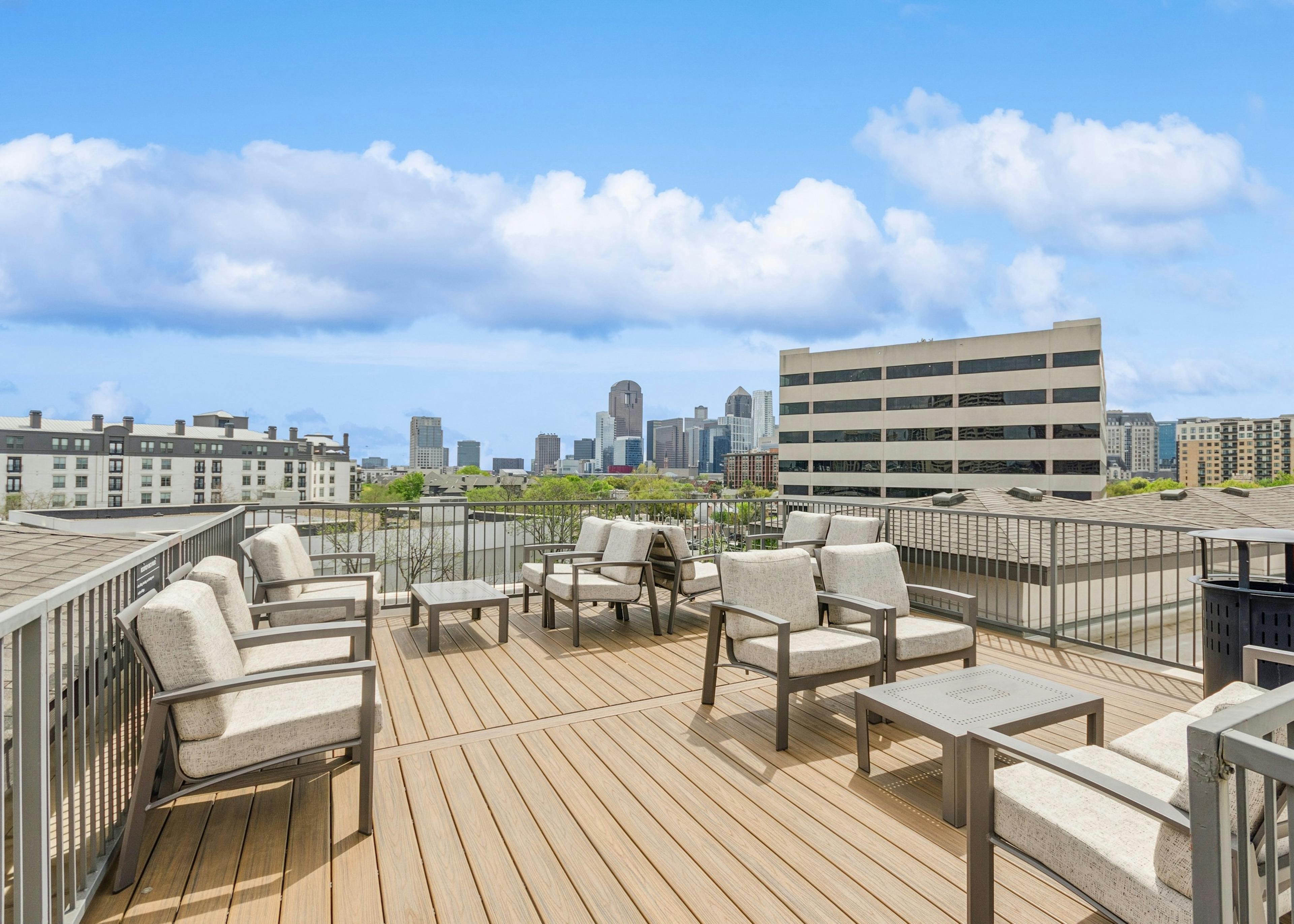 AMLI Quadrangle apartments rooftop space with taupe colored seating on decking and expansive view of city