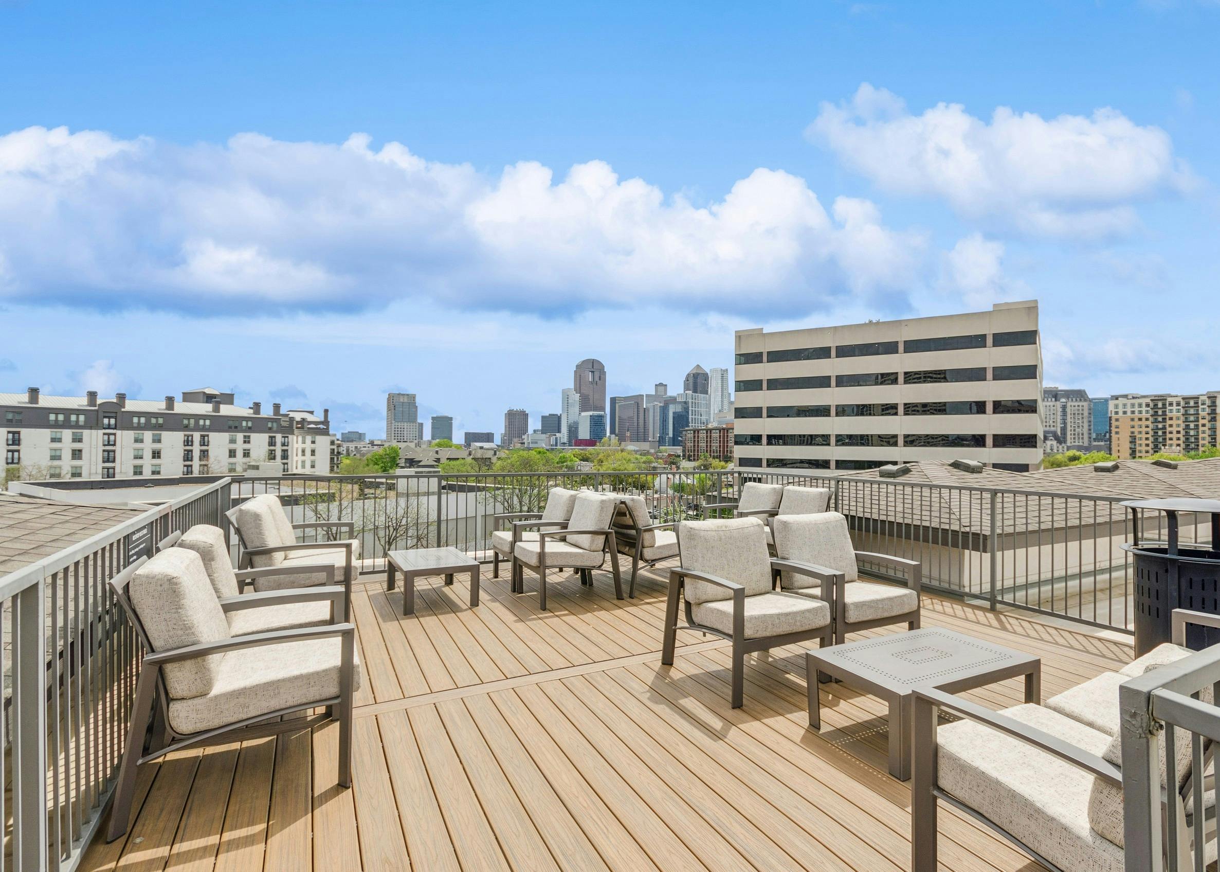 AMLI Quadrangle apartments rooftop space with taupe colored seating on decking and expansive view of city