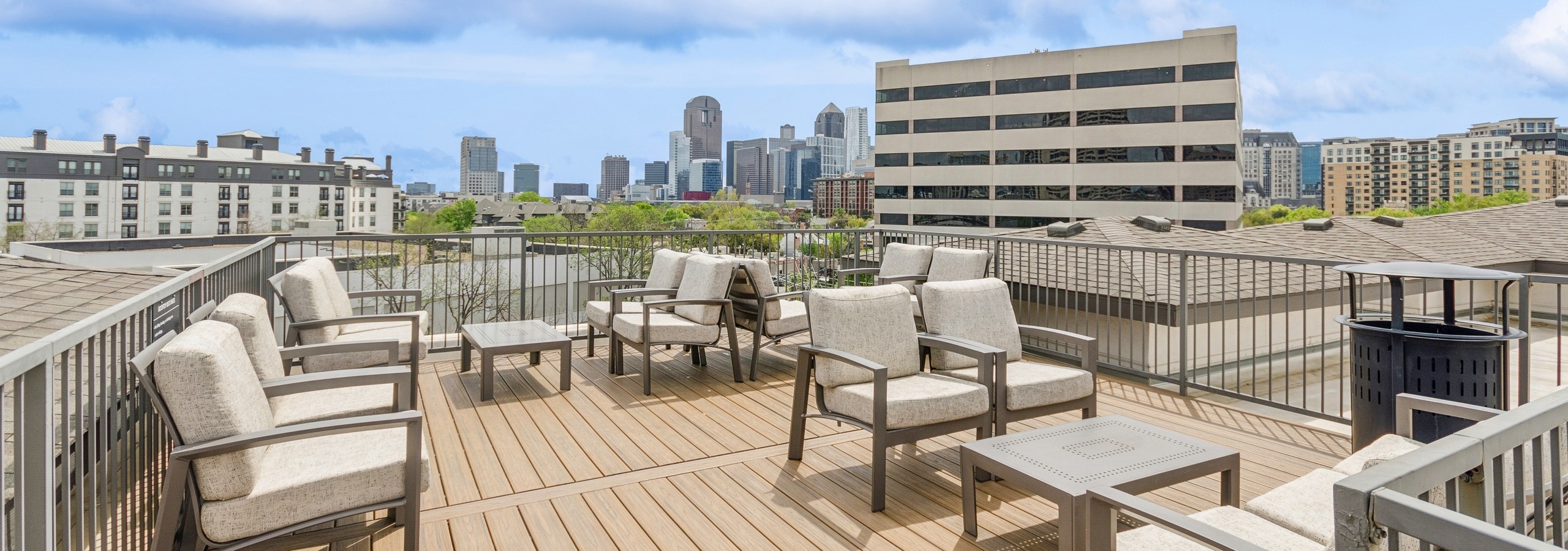AMLI Quadrangle apartments rooftop space with taupe colored seating on decking and expansive view of city