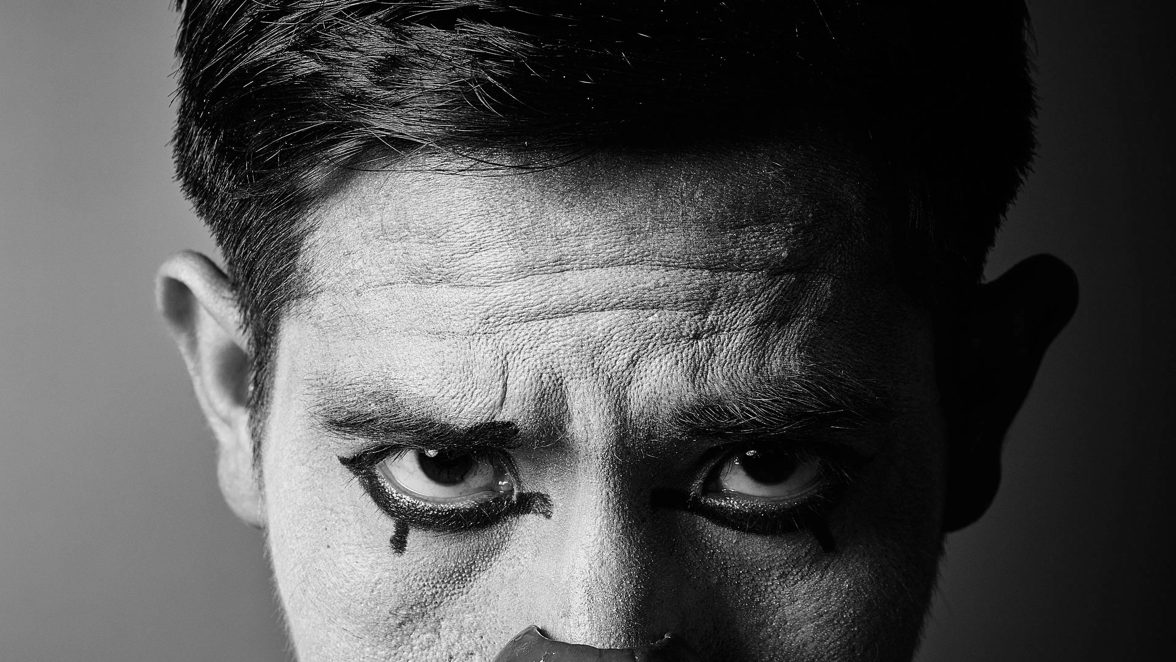 black and white photo of man dressed as sad clown