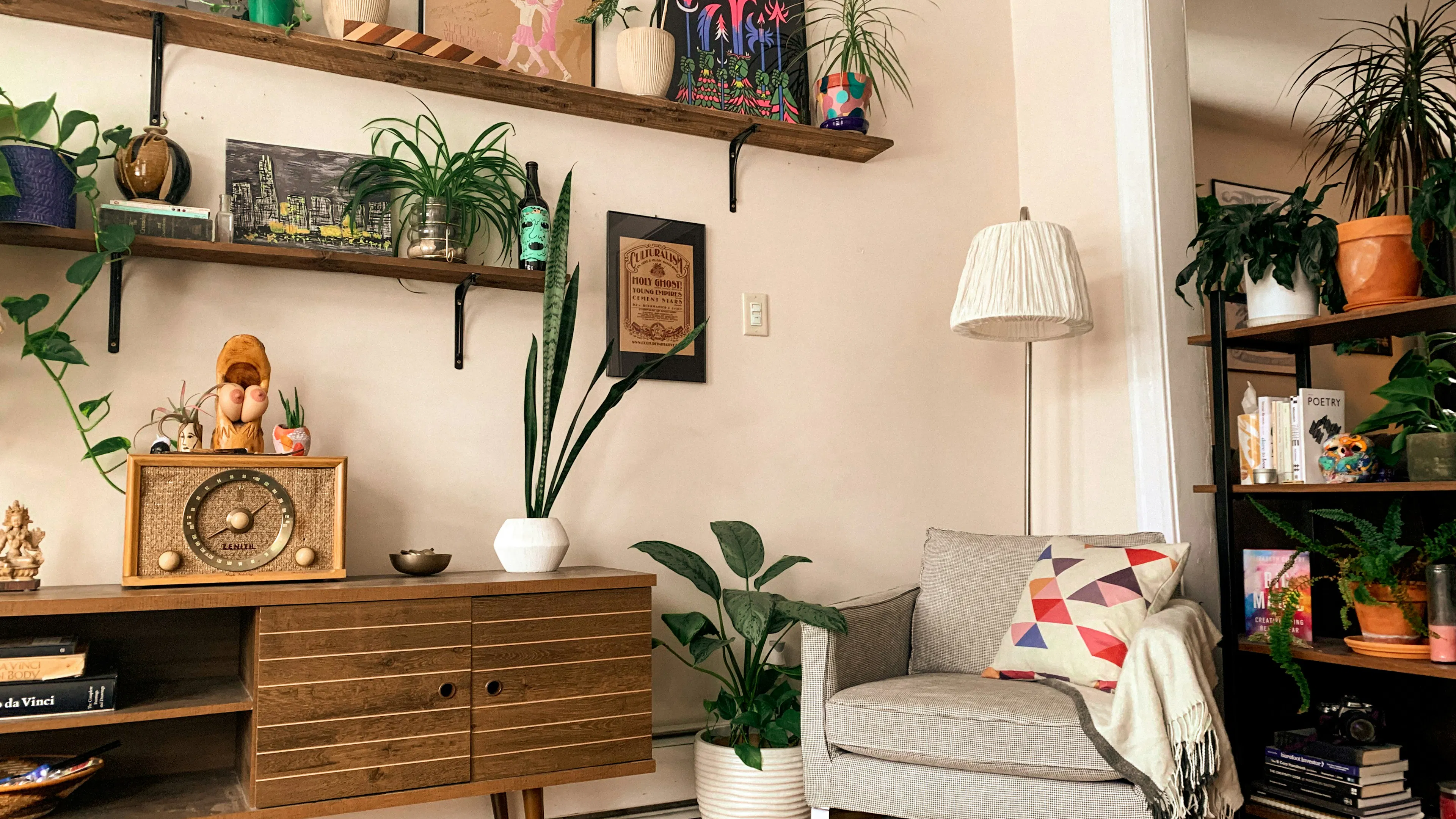 A sunny apartment interior with a retro speaker and radio decorated with plants on the walls