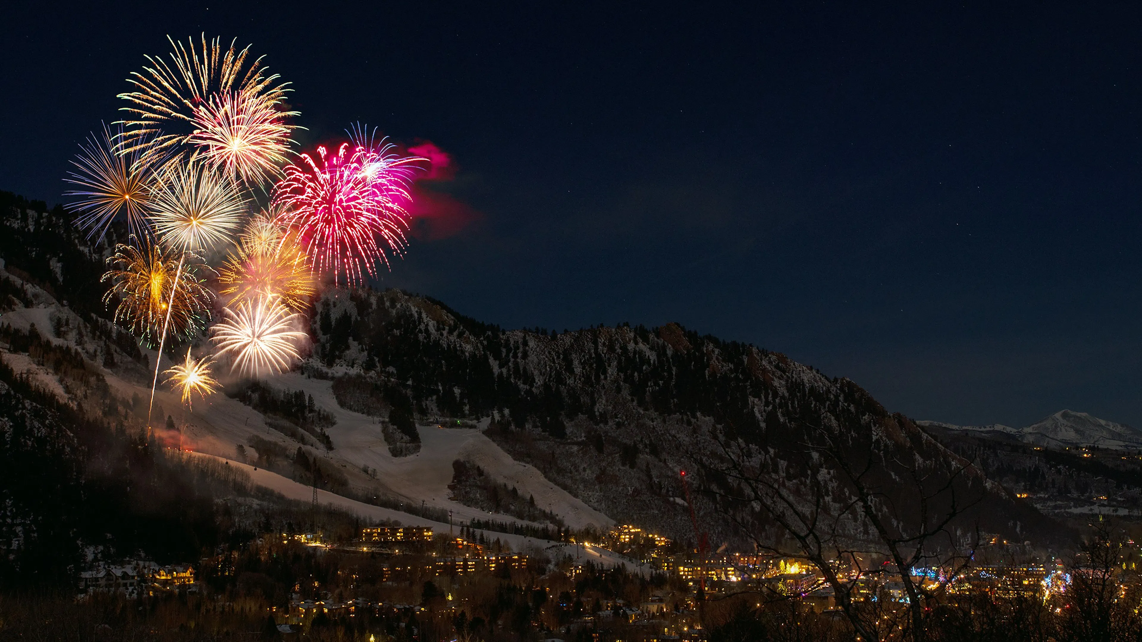 A fireworks show in a snowy mountain valley