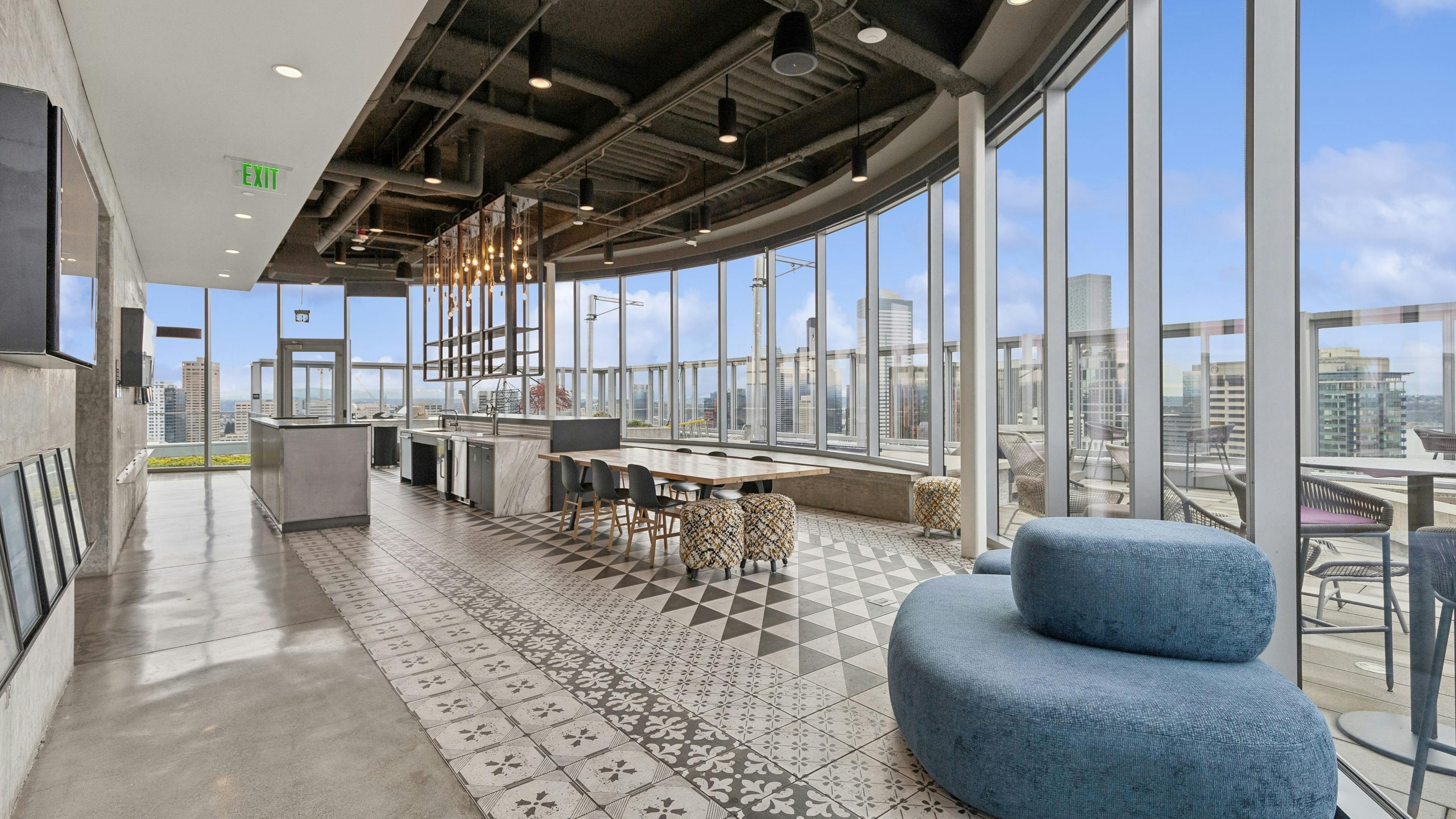 Rooftop kitchen with decorative tile flooring, modern appliances, stylish lighting, and expansive views of the city at AMLI Arc