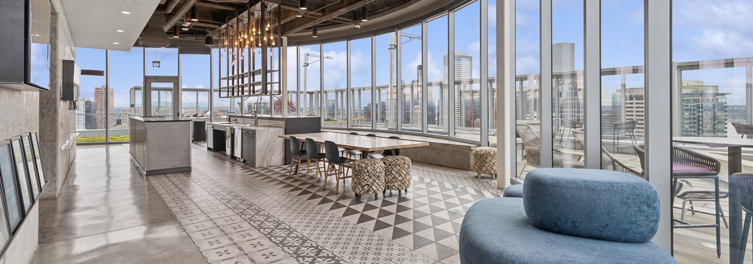 Rooftop kitchen with decorative tile flooring, modern appliances, stylish lighting, and expansive views of the city at AMLI Arc