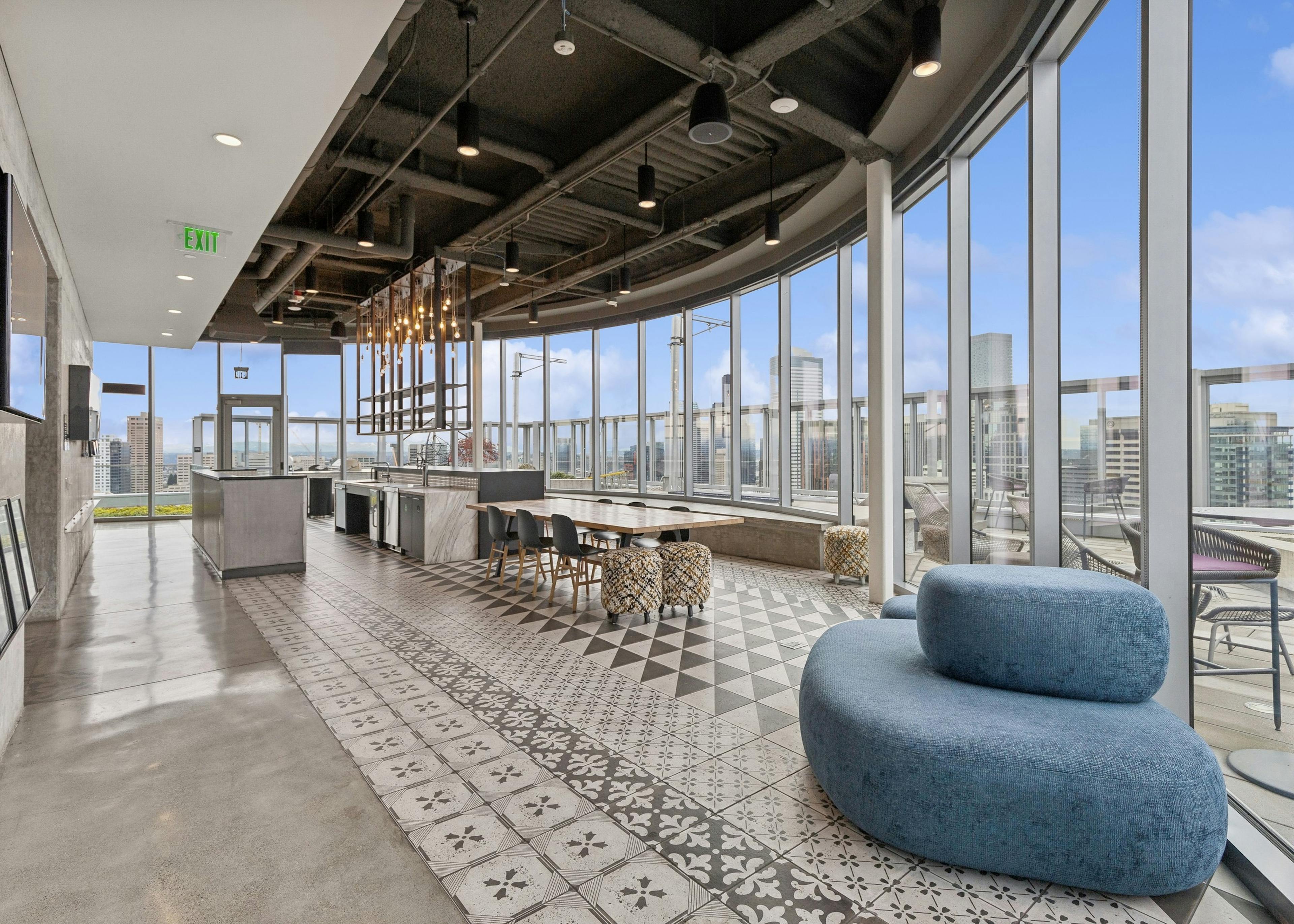 Rooftop kitchen with decorative tile flooring, modern appliances, stylish lighting, and expansive views of the city at AMLI Arc