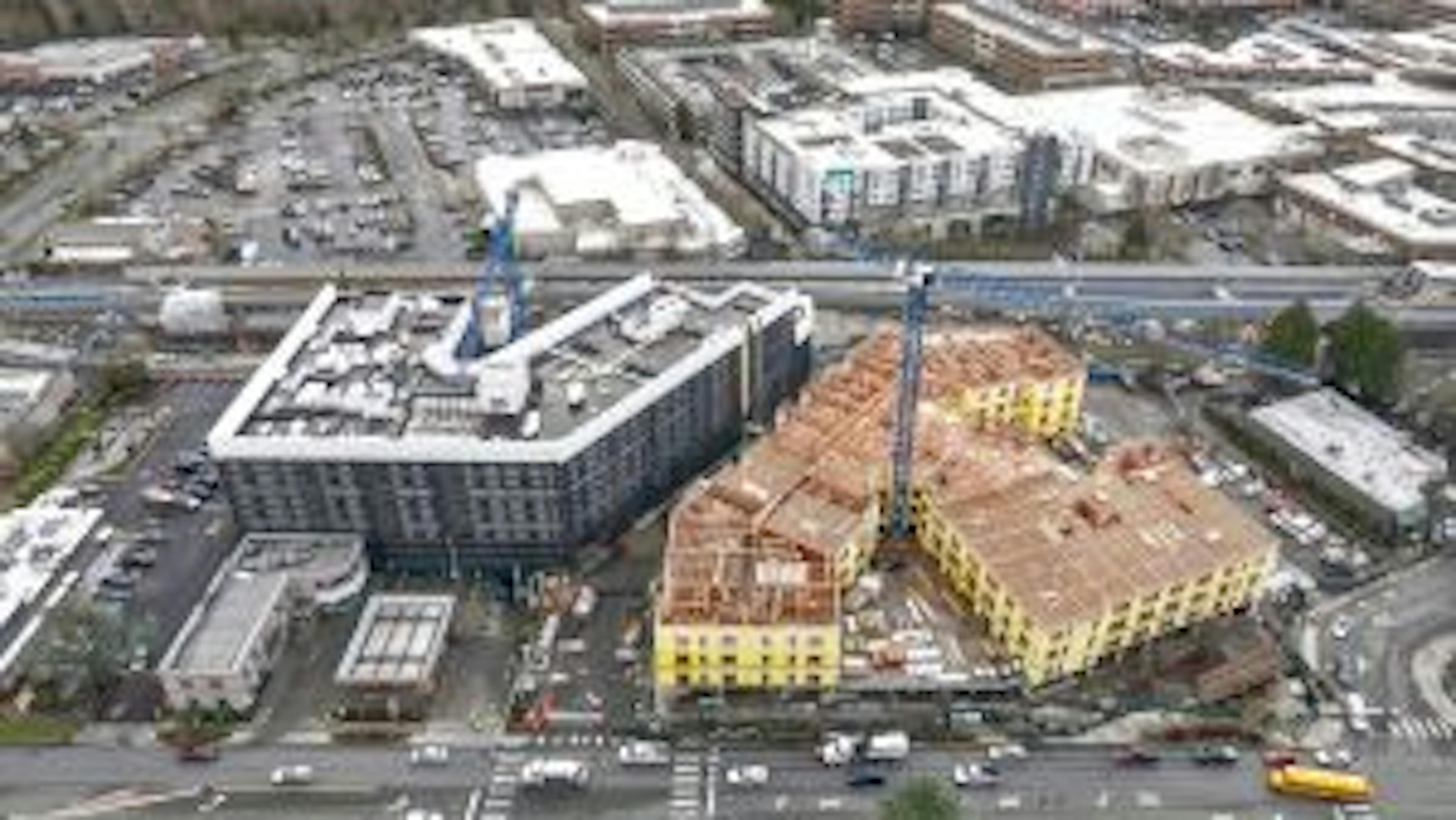 Aerial view of AMLI Redmond Way site with two blue cranes rising above two buildings under construction