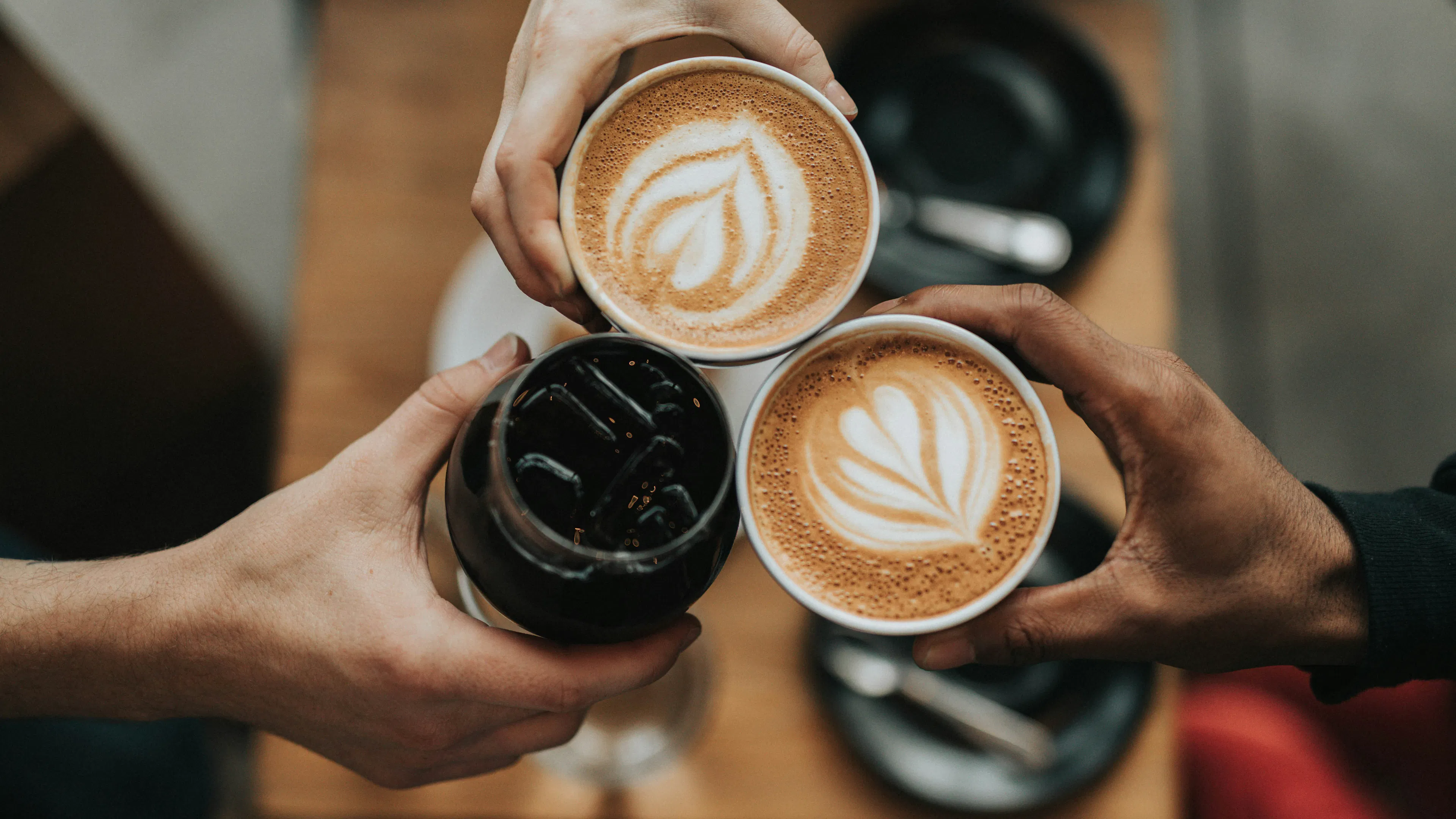 Three mugs of coffee lattes seen from above