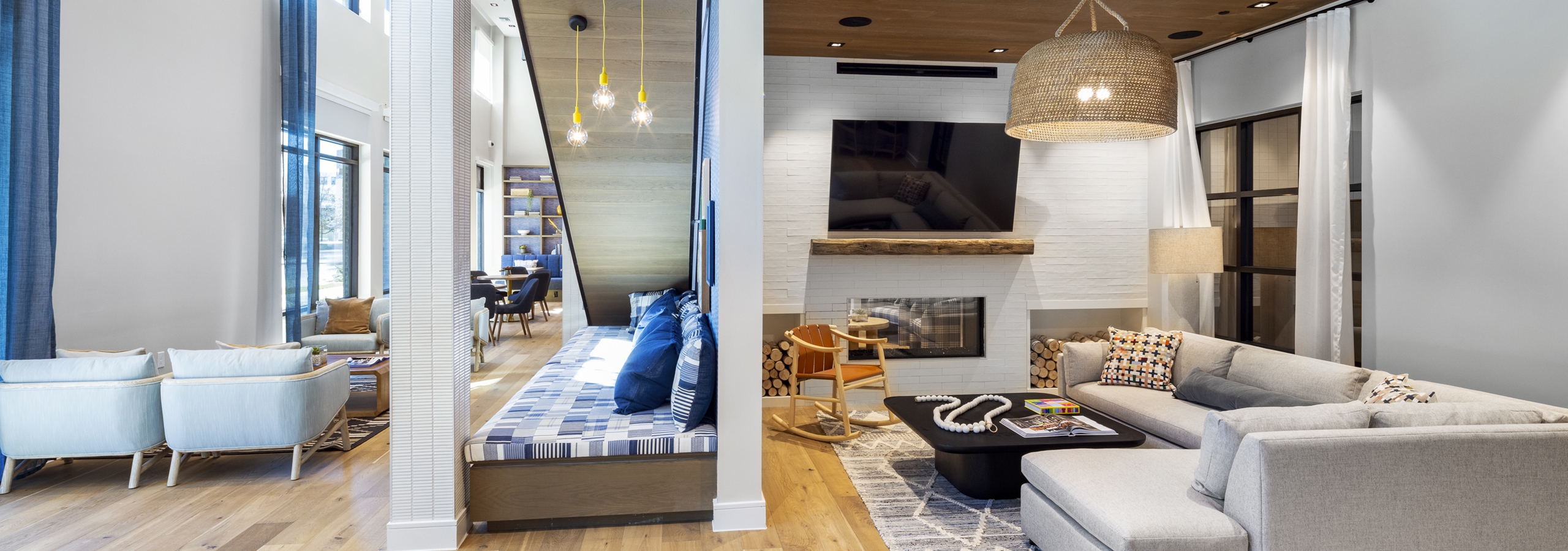 Lounge at AMLI North Park featuring a large sectional sofa, a fireplace with a TV, a woven pendant light, and a cozy built-in bench