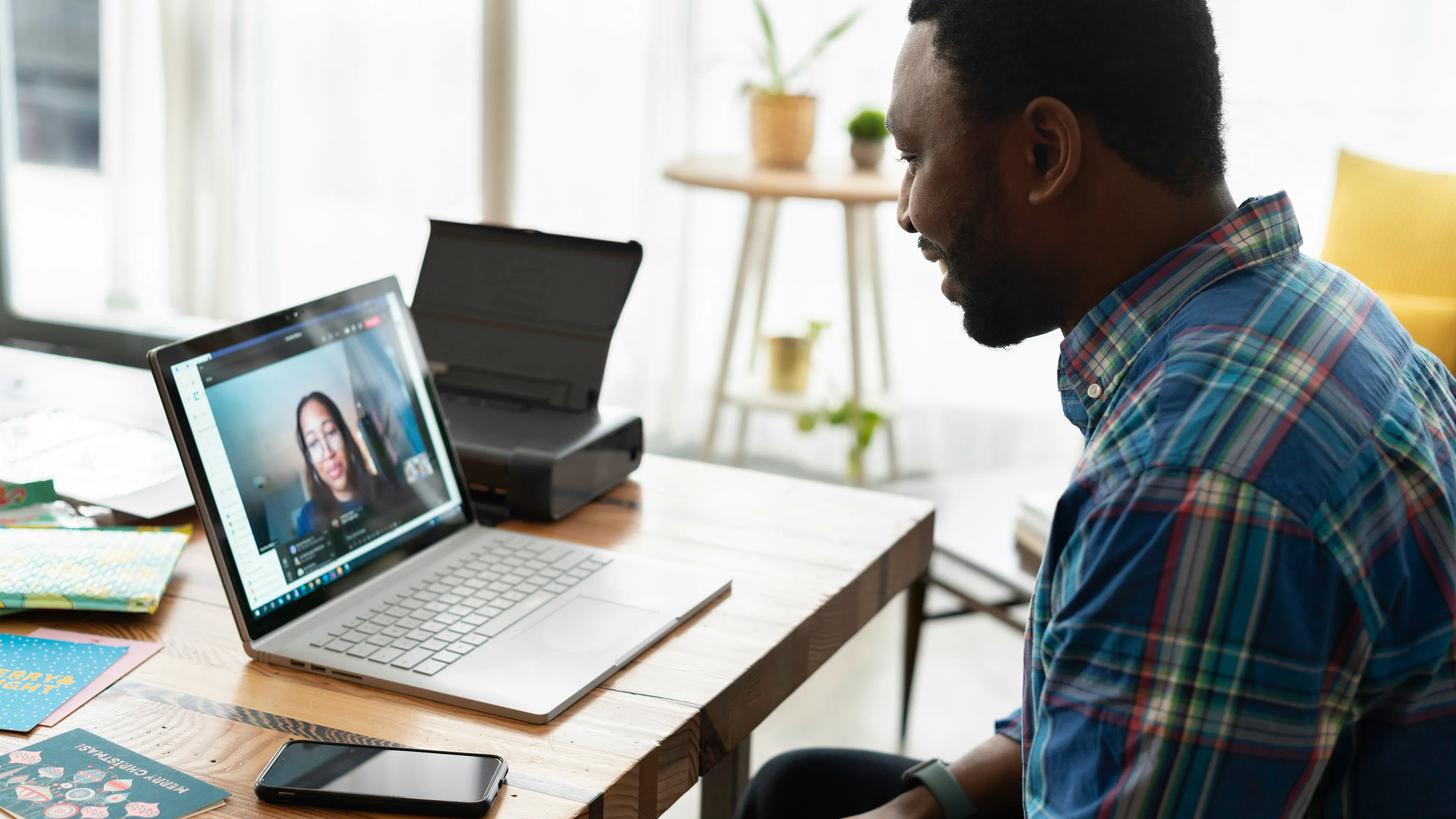 A man talking to a woman over a video call on his laptop