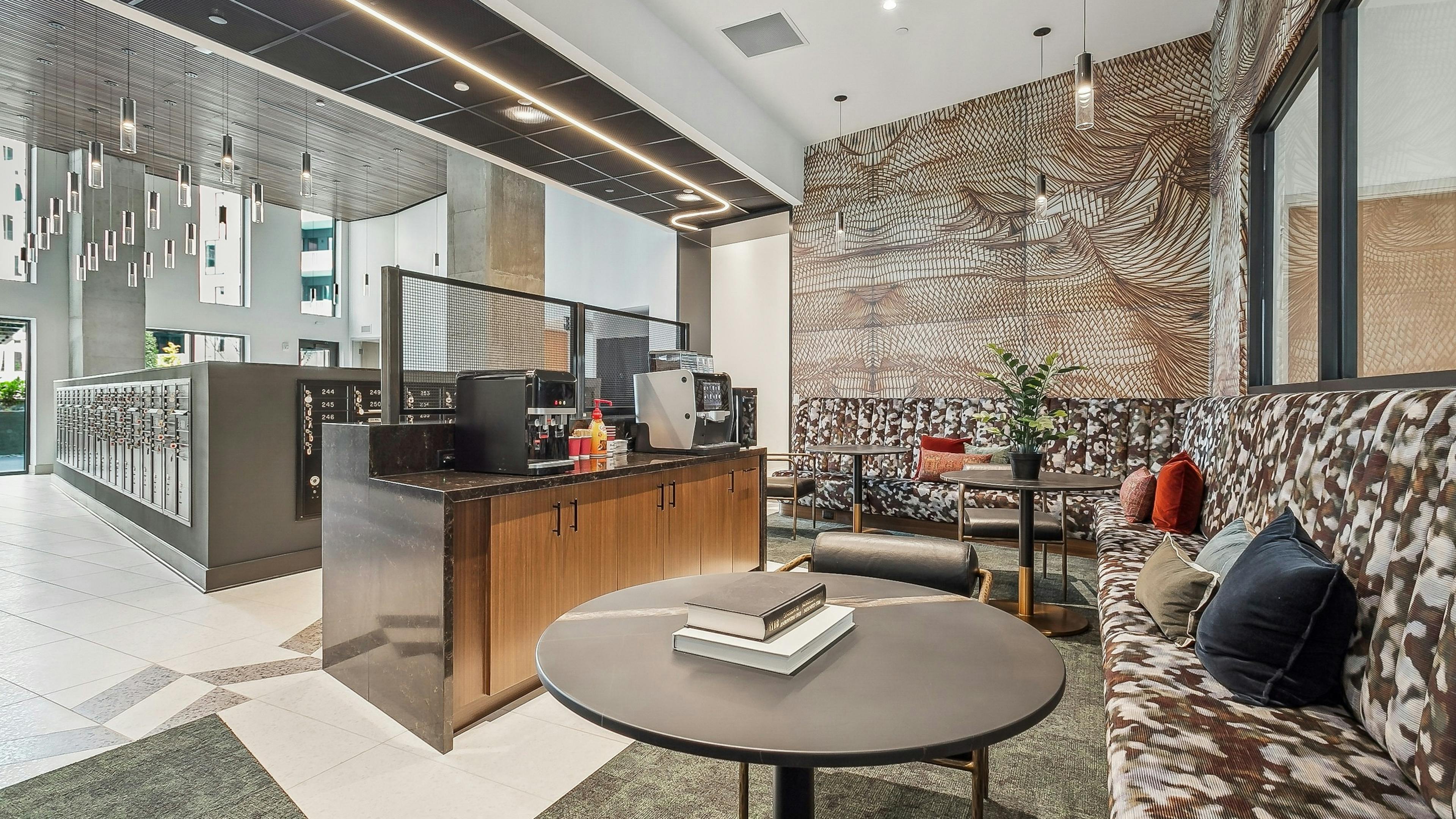 AMLI Atlantic Station mailroom lounge with patterned benches, round coffee tables and a coffee machine