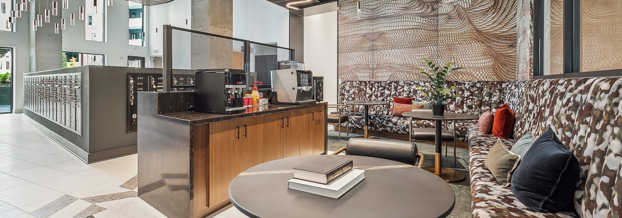 AMLI Atlantic Station mailroom lounge with patterned benches, round coffee tables and a coffee machine