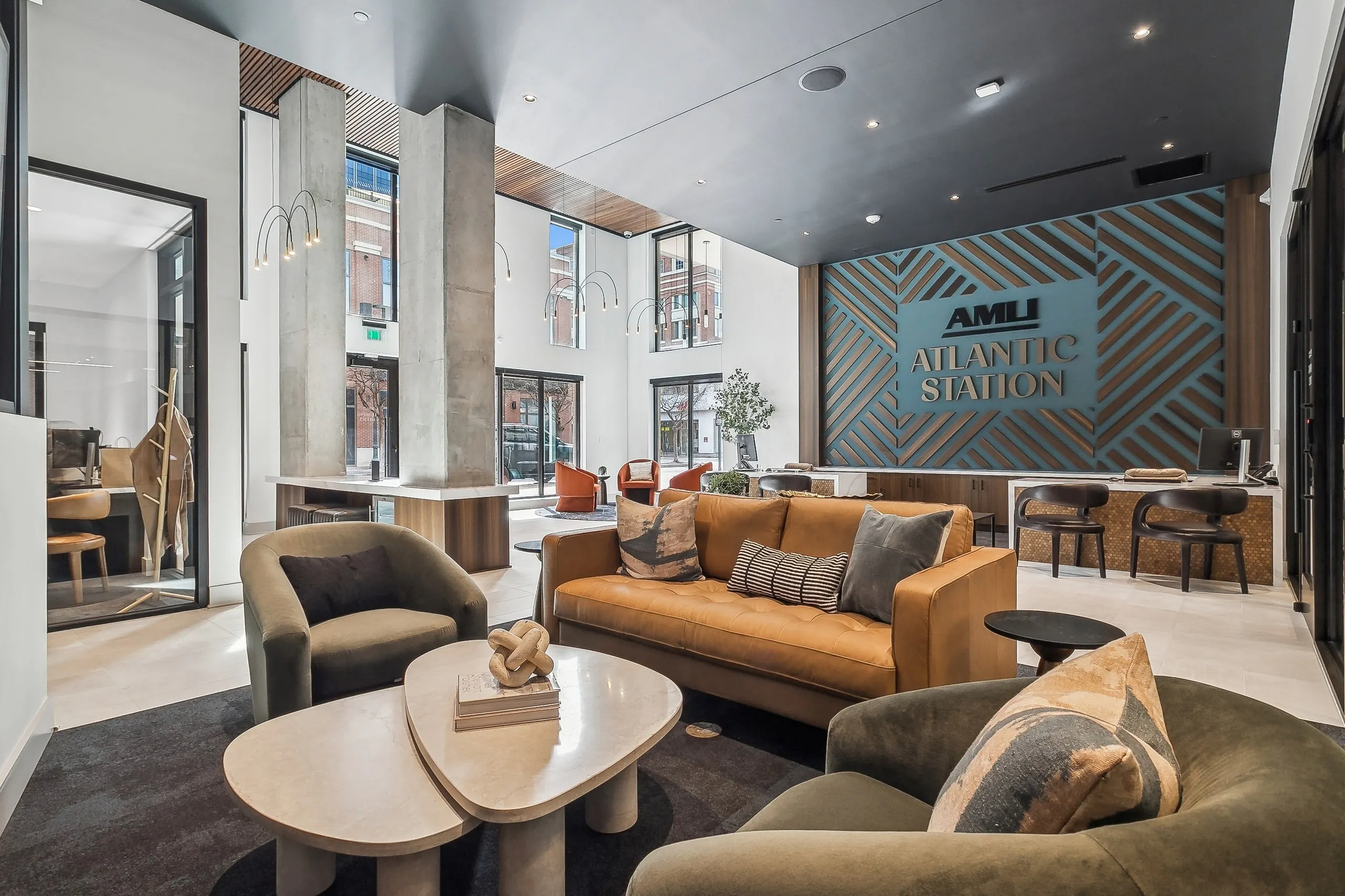 Contemporary leasing office lobby at AMLI Atlantic Station with large plush sofas and chairs, a coffee table and leasing desks