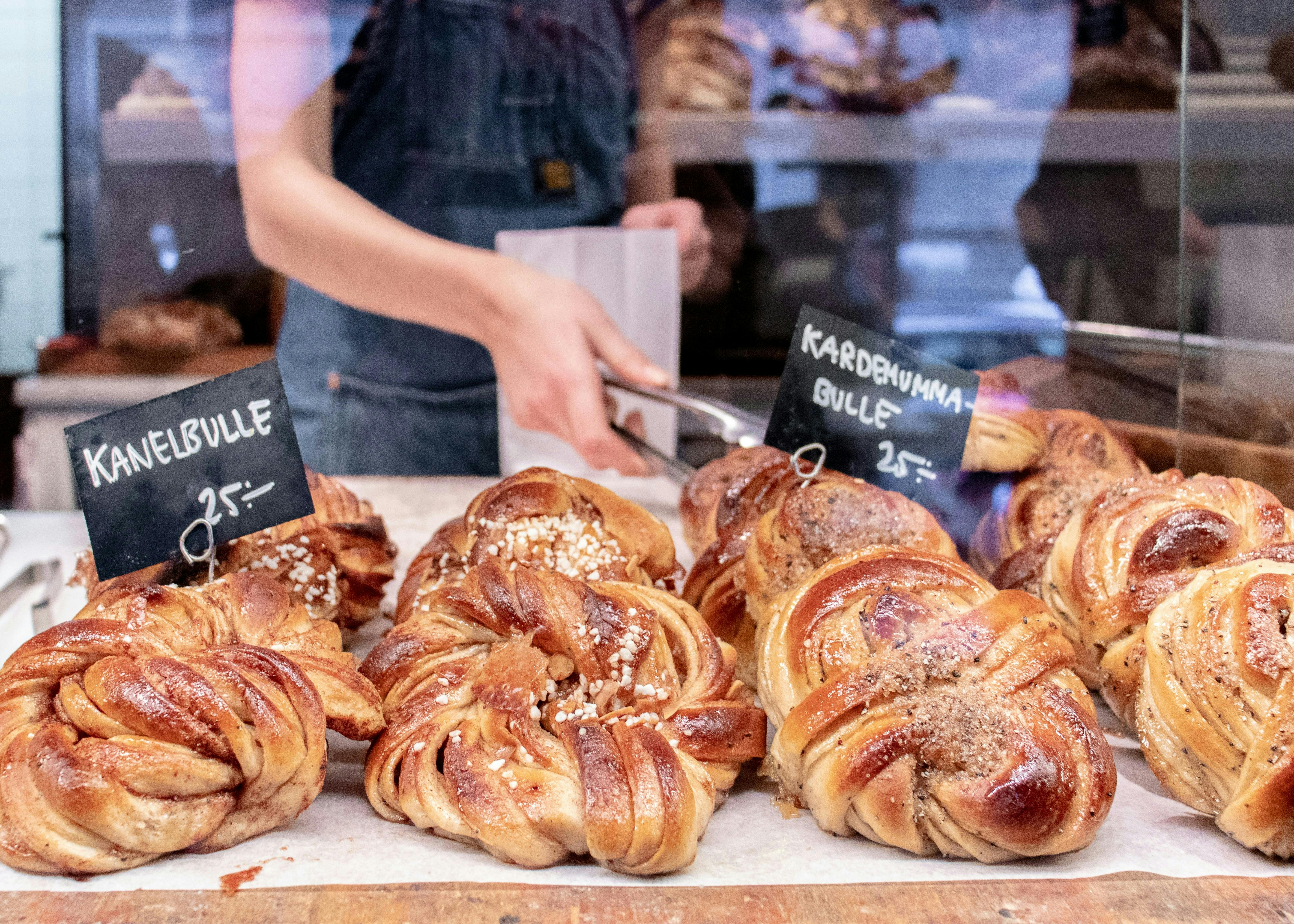 A bakery window displaying rows of fresh cinnamon buns 