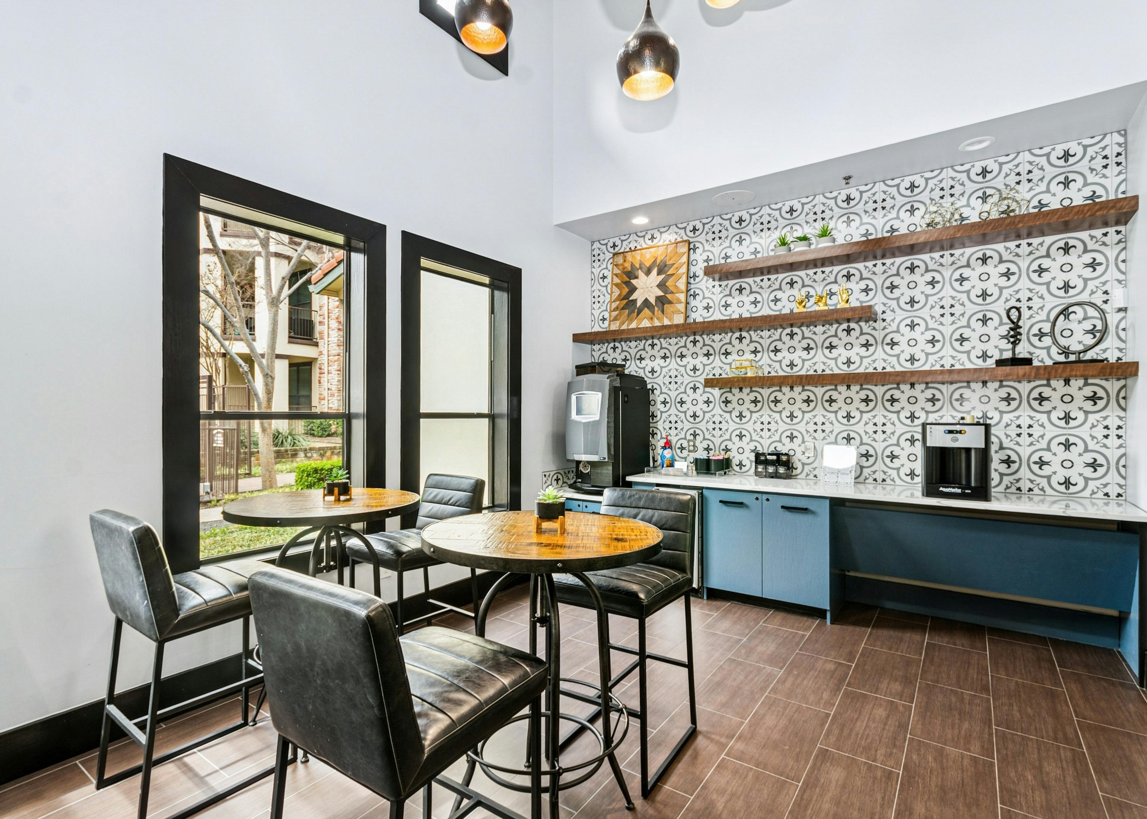 Java café for AMLI at Escena apartments with a colorful tile backsplash and leather bar stools surrounding wood high top tables