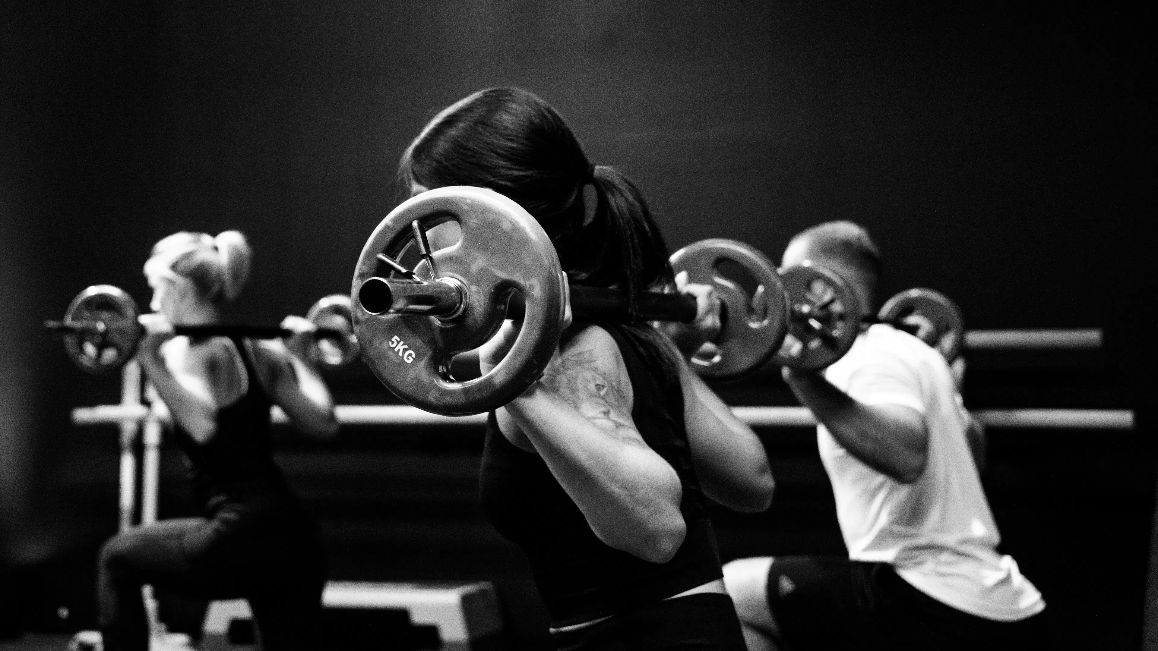 A group fitness class with barbells and steps